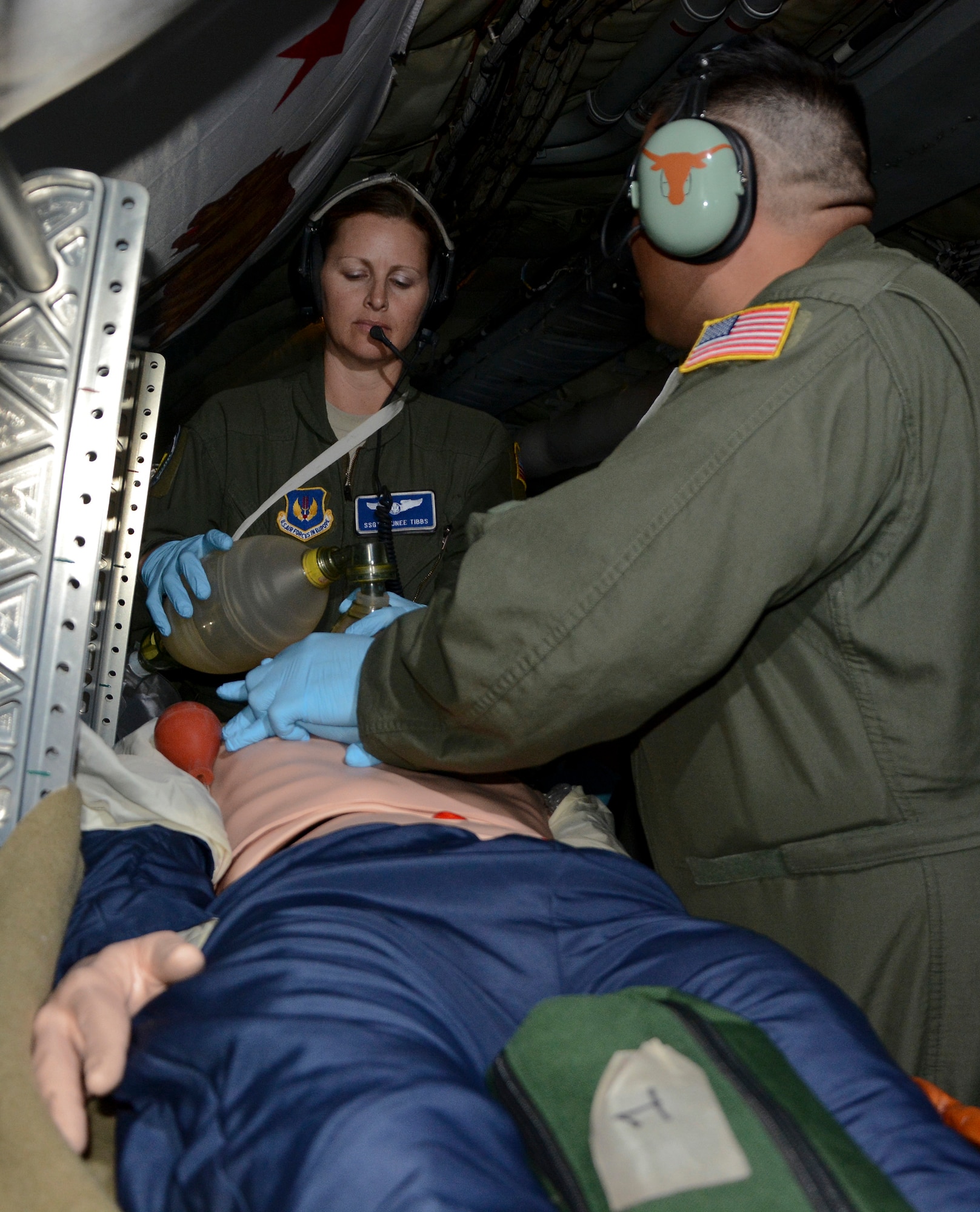 U.S. Air Force Staff Sgt. Taunee Tibbs, left, 86th Aeromedical Evacuation Squadron, Ramstein Air Base, Germany, medical technician from San Deigo, pumps oxygen into a training dummy as U.S. Air Force Staff Sgt. Rolando Rodriguez, right, 86th AES medical technician from Houston, performs chest compressions, June 24, 2014, on a KC-135 Stratotanker over Germany. Airmen from the 86th AES conducted in-flight medical training on the aircraft to get accustomed to the airframe. (U.S. Air Force photo/Senior Airman Micaiah Anthony/Released)