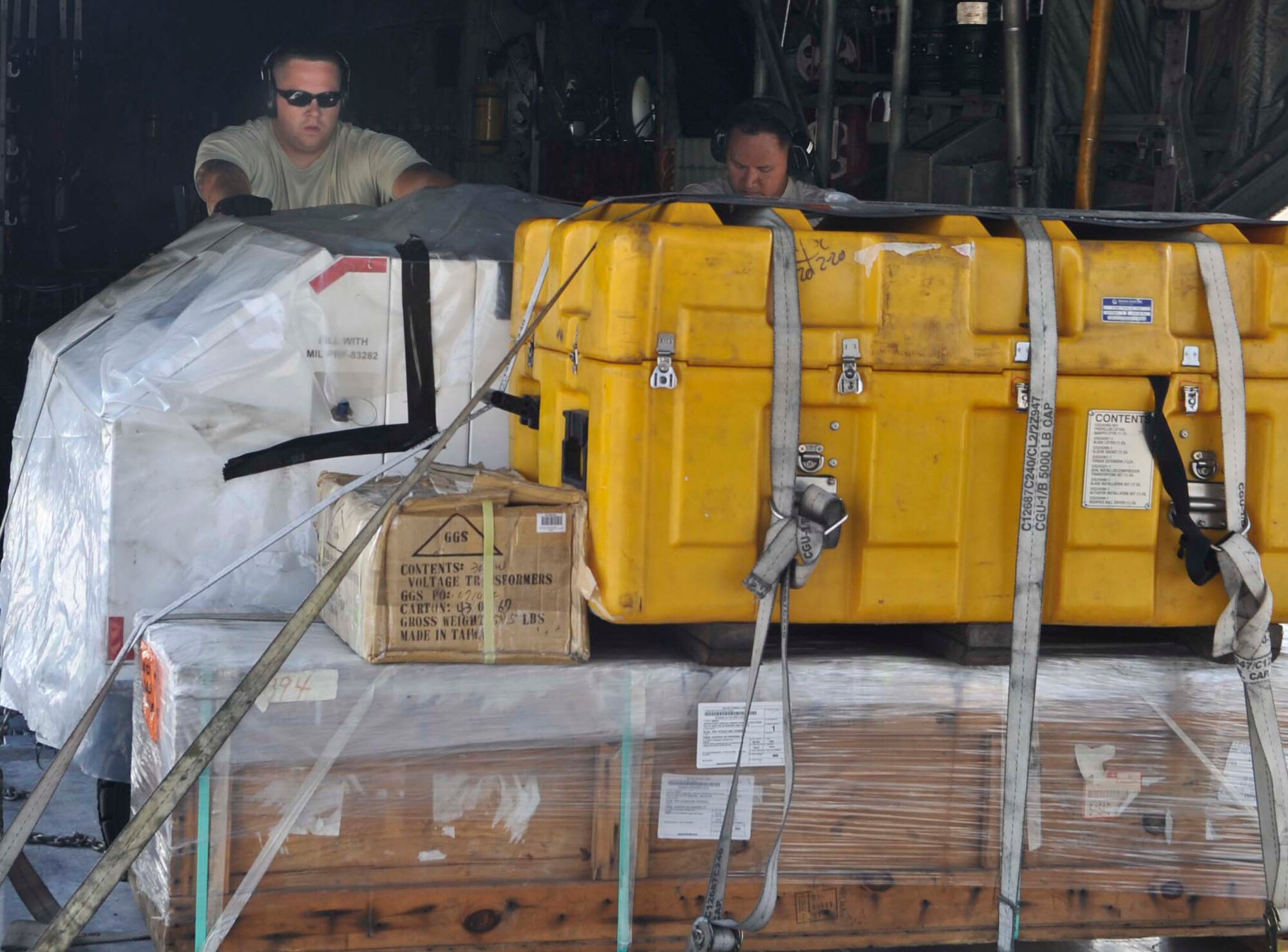Senior Airman Bradley Wolfe, 731st Air Mobility Squadron aircraft services journeyman, and Tech. Sgt. Paul Bersabe, 731st AMS aircraft services supervisor, unload pallets at Osan Air Base, Republic of Korea, July 10, 2014. The 731st AMS is the main airlift hub for all Household Goods, personal property and cargo throughout the ROK peninsula. (U.S. Air Force photo/Senior Airman Matthew Lancaster)