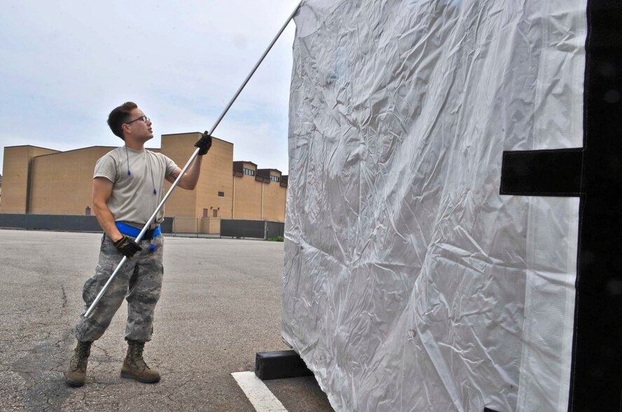 Airman 1st Class Joseph Shank, 731st Air Mobility Squadron aircraft services technician, uses a pallet cover pole to remove a reusable pallet cover at Osan Air Base, Republic of Korea, July 10, 2014. The pallet cover poles were designed to assist with the putting on and taking off of the reusable pallet cover. (U.S. Air Force photo/Senior Airman Matthew Lancaster)