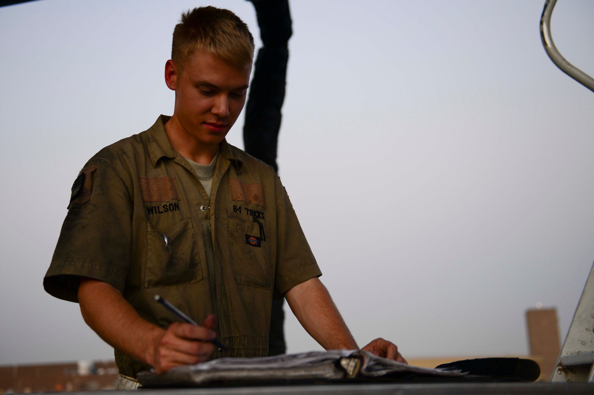 U.S. Air Force Senior Airman Jacob Wilson, 379th Expeditionary Aircraft Maintenance Squadron B-1B electrician, completes checklists for a B1-B Lancer at Al Udeid Air Base, Qatar, July 8, 2014. Checklists are completed to ensure the aircraft are prepared and capable of continuing missions in support of Operation Enduring Freedom. Wilson is deployed from Ellsworth Air Force Base, South Dakota. (U.S. Air Force photo by Staff Sgt. Ciara Wymbs) 