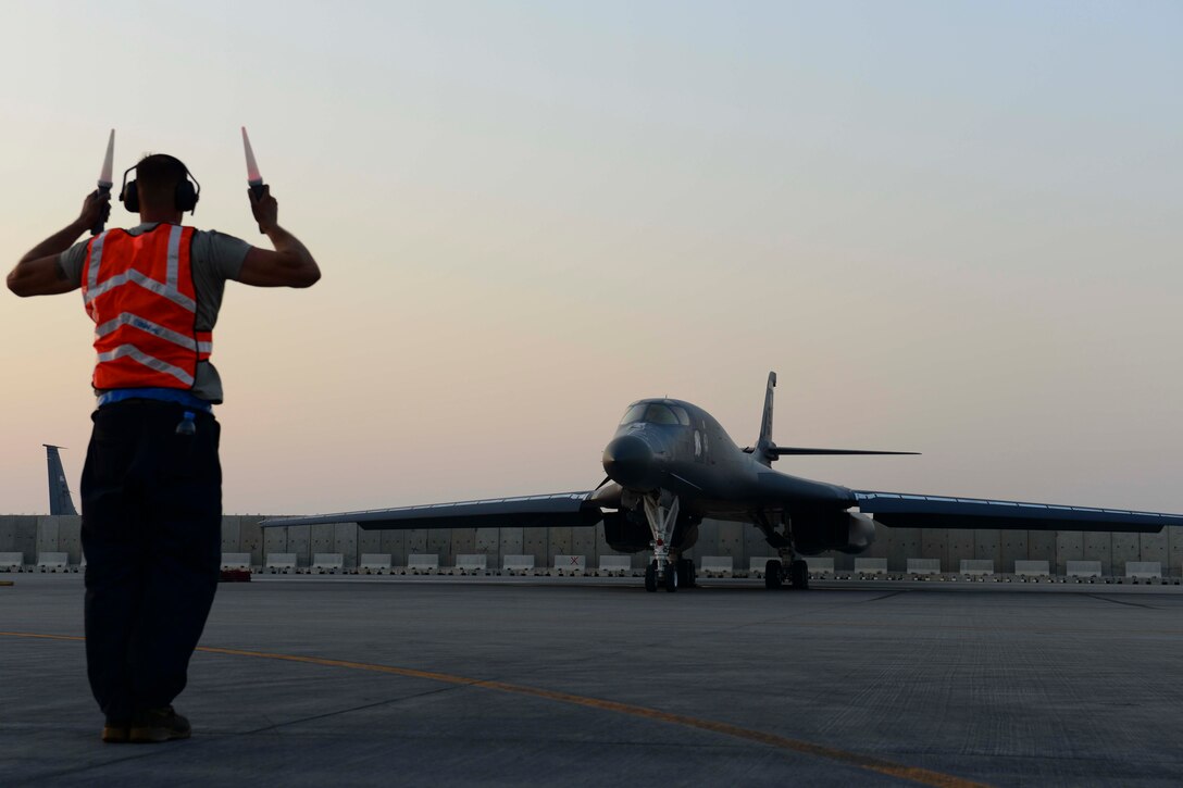 U.S. Air Force Senior Airman Jordan Duncan, 379th Expeditionary Aircraft Maintenance Squadron B-1B crew chief, marshals a B-1B Lancer prior to takeoff at Al Udeid Air Base, Qatar, July 8, 2014. Crew chiefs are responsible for ensuring the aircraft are inspected and have functional checks completed as well as making sure the aircraft has been serviced with fuel, hydraulic fluid and liquid oxygen. Duncan is deployed from Ellsworth Air Force Base, South Dakota. (U.S. Air Force photo by Staff Sgt. Ciara Wymbs)