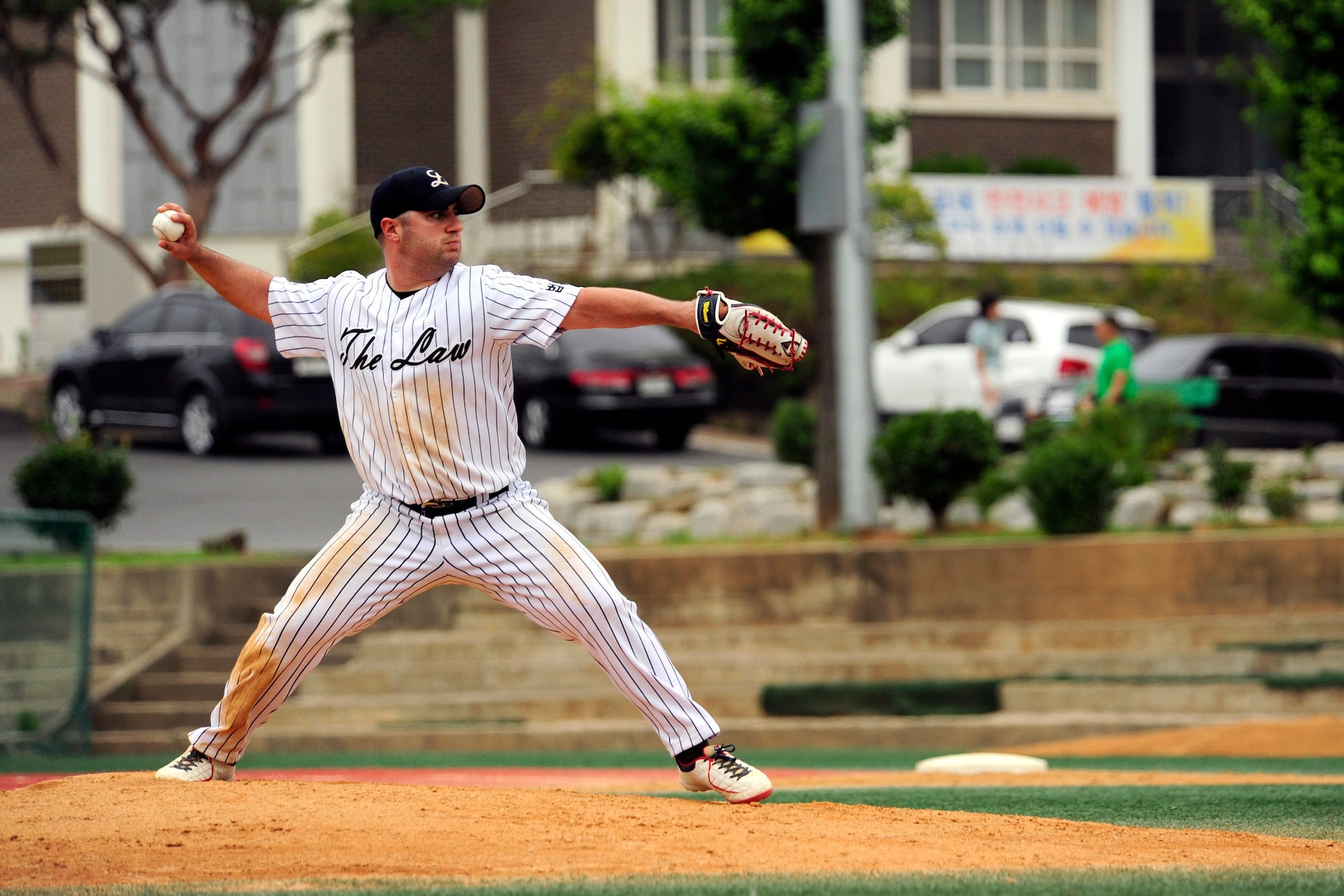 1st Lt. Salvatore Randazzo, 8th Civil Engineer Squadron installation management flight commander, pitches the ball during the American-Korean baseball game at the Kunsan Sang High School in Munhwadong, Gunsan City, Republic of Korea, June 21, 2014. The game highlights the lasting partnership on the peninsula and to experience each other’s cultures as they operate as a team. The game’s final score was 22 to 21, with the Korean team taking the win. (U.S. Air Force photo by Senior Airman Taylor Curry/Released) 