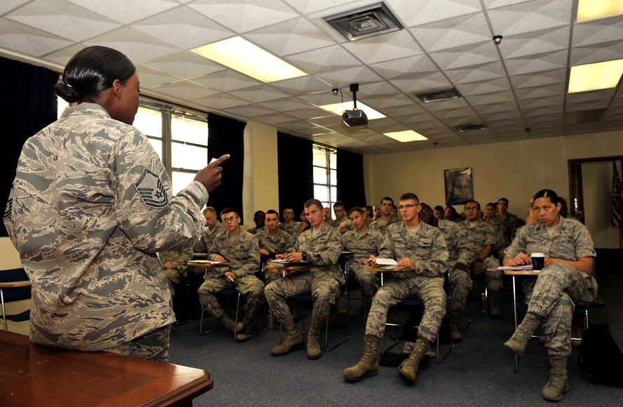 U.S. Air Force Master Sgt. Karla Peters, 18th Force Support Squadron superintendent of customer service, briefs Airmen in-processing on Kadena Air Base, Japan, July 11, 2014. All newcomers must in-process at the military personnel section first prior to attending Base Newcomer's Orientation. They also must visit the 18th Security Forces Squadron Pass and Registration section to get registered in the Defense Biometric Identification System within 72 hours of arrival on station. (U.S. Air Force photo by Naoto Anazawa/Released)