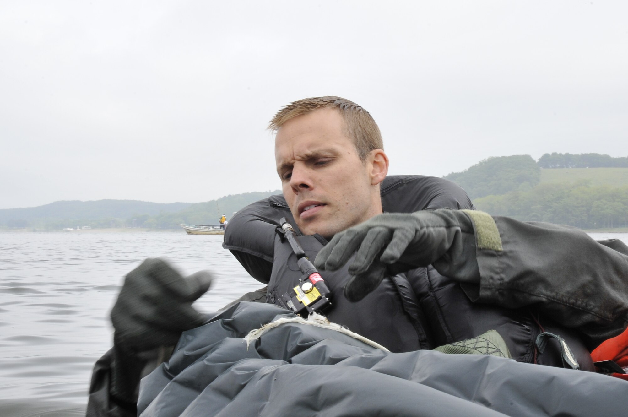 U.S. Air Force Capt. Kevin Anderson, 14th Fighter Squadron weapons officer, engages his life raft’s storm shield during a Survival Evasion Resistance and Escape water survival course at Misawa Air Base, Japan, June 18, 2014. The shield offers two different functions upon inflating: It shields the raft occupant from harsh weather conditions and provides camouflage from enemy surveillance. (U.S. Air Force photo/Airman 1st Class Patrick S. Ciccarone)