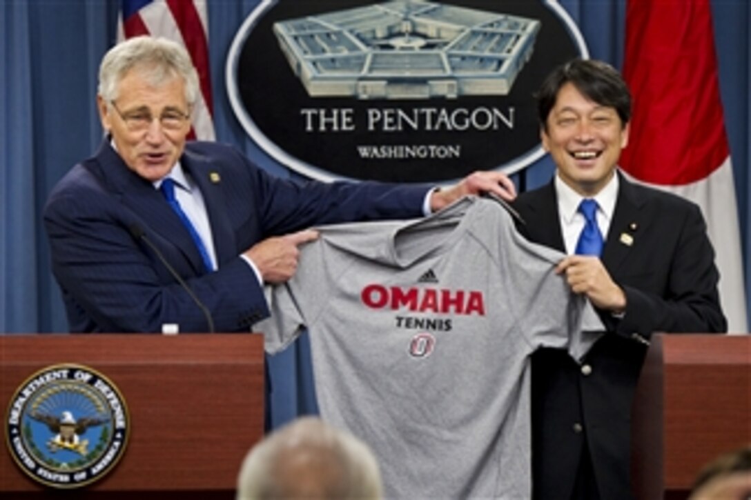 U.S. Defense Secretary Chuck Hagel, left, gives Japanese Defense Minister Itsunori Onodera a University of Nebraska tennis shirt at the Pentagon, July 11, 2014. The two defense leaders met to discuss issues of mutual interest. 