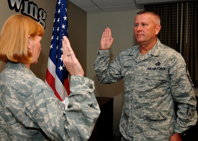 Senior Master Sgt. William Bassett, 932nd Airlift Wing, superintendent of the base command post, reenlisted for three more years in the Air Force Reserve. Bassett was read the oath of enlistment by Lt. Col. Michelle Huffman, 932nd Airlift Wing director of staff on July 12, 2014. (U.S. Air Force Photo/ Staff Sgt. Amber Hodges)