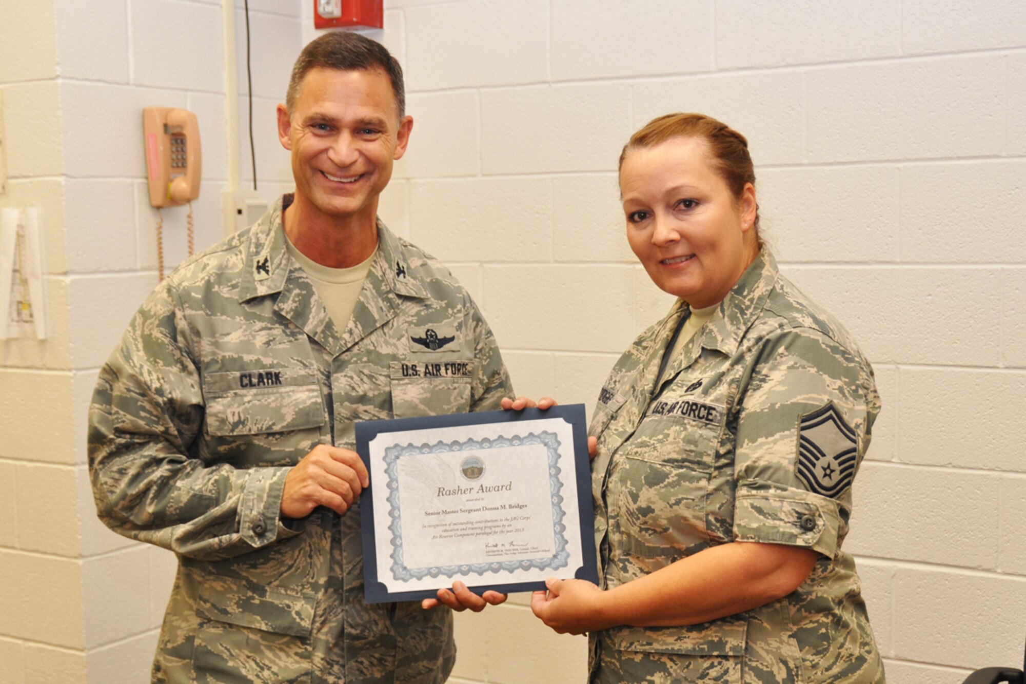 Col. Brett Clark, 94th Airlift Wing commander, recognizes Senior Master Sgt. Donna M. Bridges, 94th AW law office superitendent, for recently being awarded the Donald C. Rasher Award for her outstanding contributions to the Air Force Judge Advocate General Corps July 12, 2014, during the Unit Training Assembly. The award recognizes the Air Reserve Component paralegal who contributed the most to the education and training of the JAG Corps during 2013.