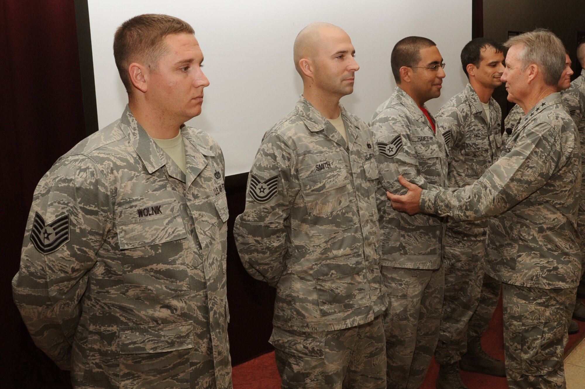 Gen. Hawk Carlisle, Pacific Air Forces commander, congratulates and coins six Airmen during a visit to Kadena Air Base, Japan, July 11, 2014. Carlisle visited Kadena to emphasize the vital role in maintaining regional stability as the "Keystone of the Pacific." (U.S. Air Force photo by Airman 1st Class Zackary A. Henry / Released)
