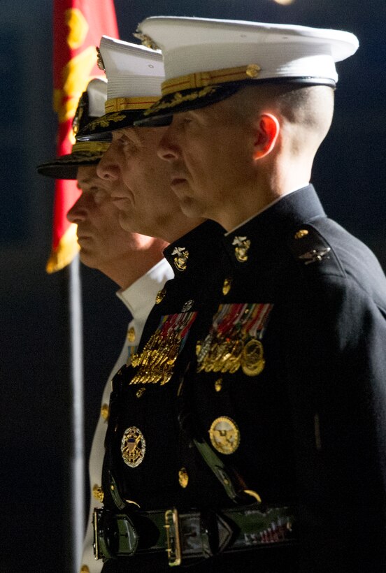 Navy Adm. James A. Winnefeld Jr., left, vice chairman of the Joint Chiefs of Staff, Marine Corps Assistant Commandant Gen. John M. Paxton Jr., center, and Marine Corps Col. Benjamin T. Watson, garrison commander, stand at attention during the pass and review portion of the evening parade at Marine Barracks Washington, D.C., July 11, 2014. 