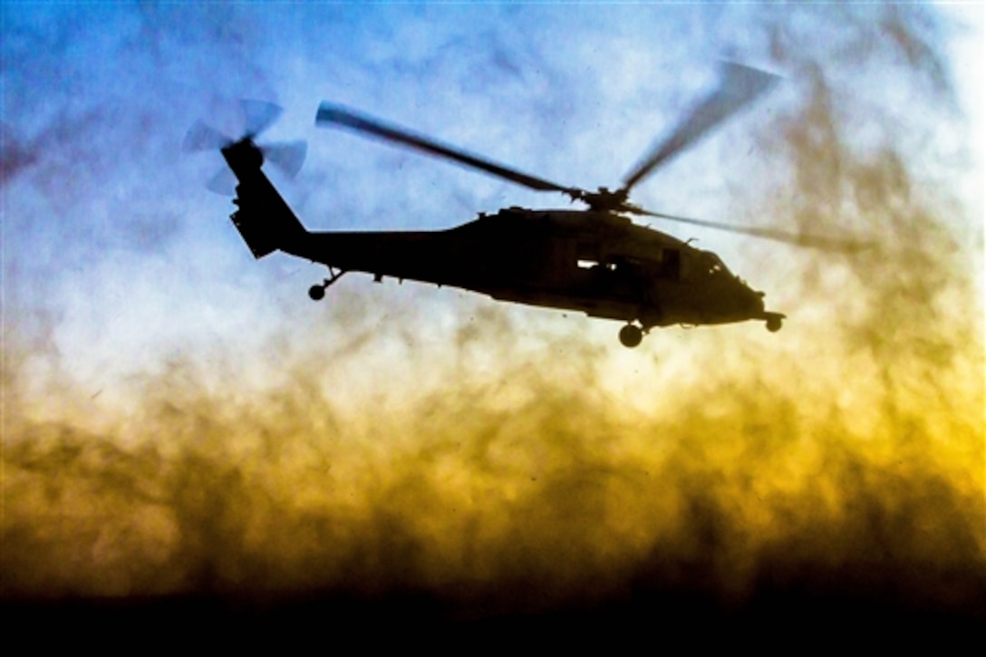 A Navy MH-60S Seahawk helicopter assigned to the aircraft carrier USS George H.W. Bush takes off after a joint fire exercise with Army AH-64 Apaches and Air Force joint terminal attack controllers near Camp Buehring, Kuwait, July 8, 2014. The Army Apaches are assigned to 3rd Battalion, 159th Attack Reconnaissance Battalion, 42nd Combat Aviation Brigade, and the Air Force controllers are assigned to the 82nd Expeditionary Air Operations Squadron.