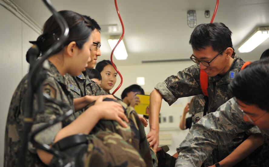 Students from the Republic of Korea Aeromedical Center Primary Flight Nurse Course simulate decontaminating a mock chemical attack casualty during a tour of the 51st Medical Group at Osan Air Base, ROK, July 11, 2014. The nurses represented different branches of the ROK military and used the tour to discuss the similarities and differences of flight nurse responsibilities and training in the ROK and U.S. armed forces. (U.S. Air Force photo/Airman 1st Class Ashley J. Thum)