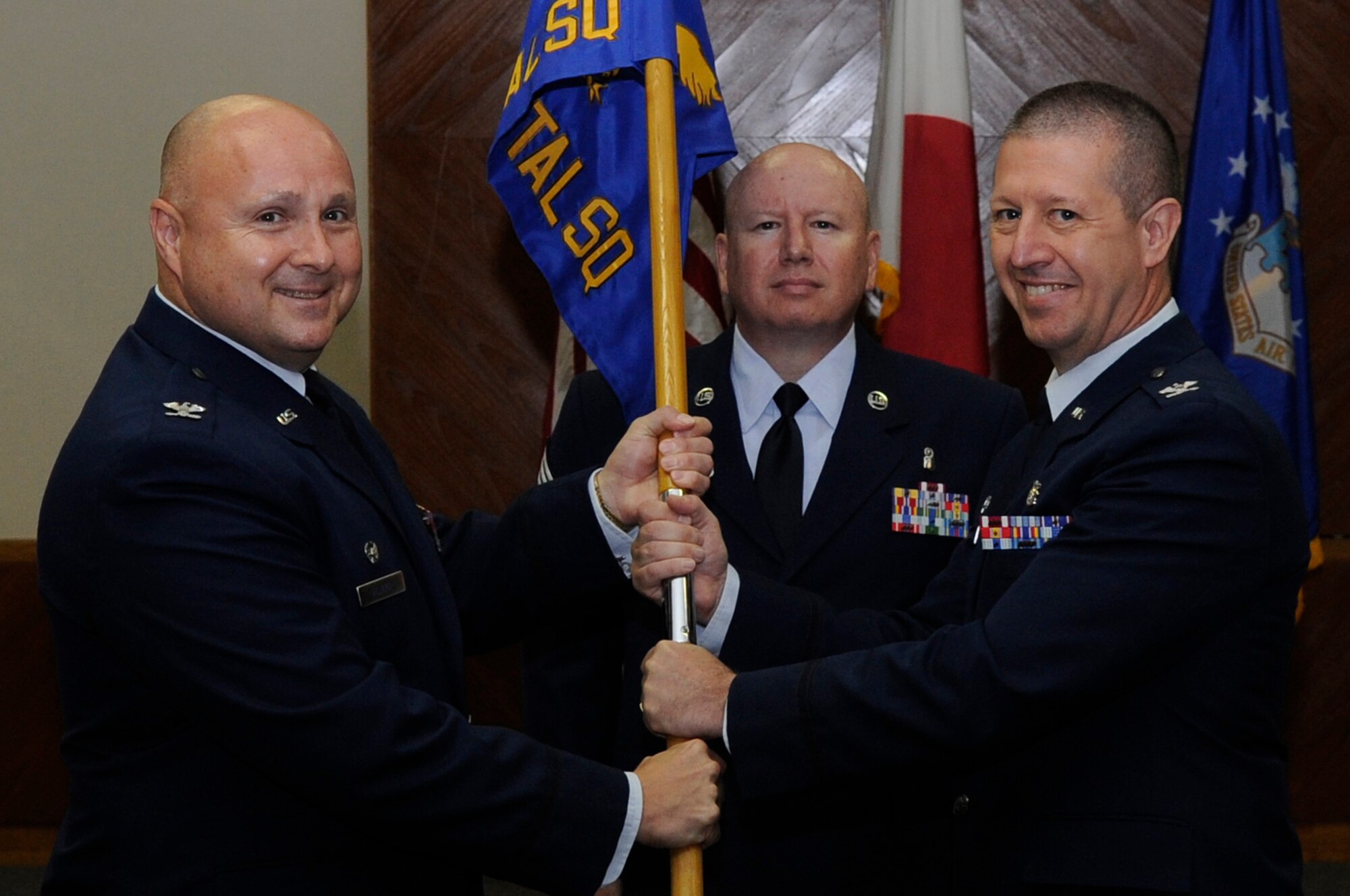 U.S. Air Force Col. Frank Allara, former 18th Dental Squadron commander, passes the squadron guidon to Col. Scott Schubkegel, 18th DS commander, at Kadena Air Base, Japan, July 14, 2014. Schubkegel previously served as the 48th Dental Squadron commander at Royal Air Force Lakenheath, England. (U.S. Air Force photo by Senior Airman Marcus Morris/Released) 