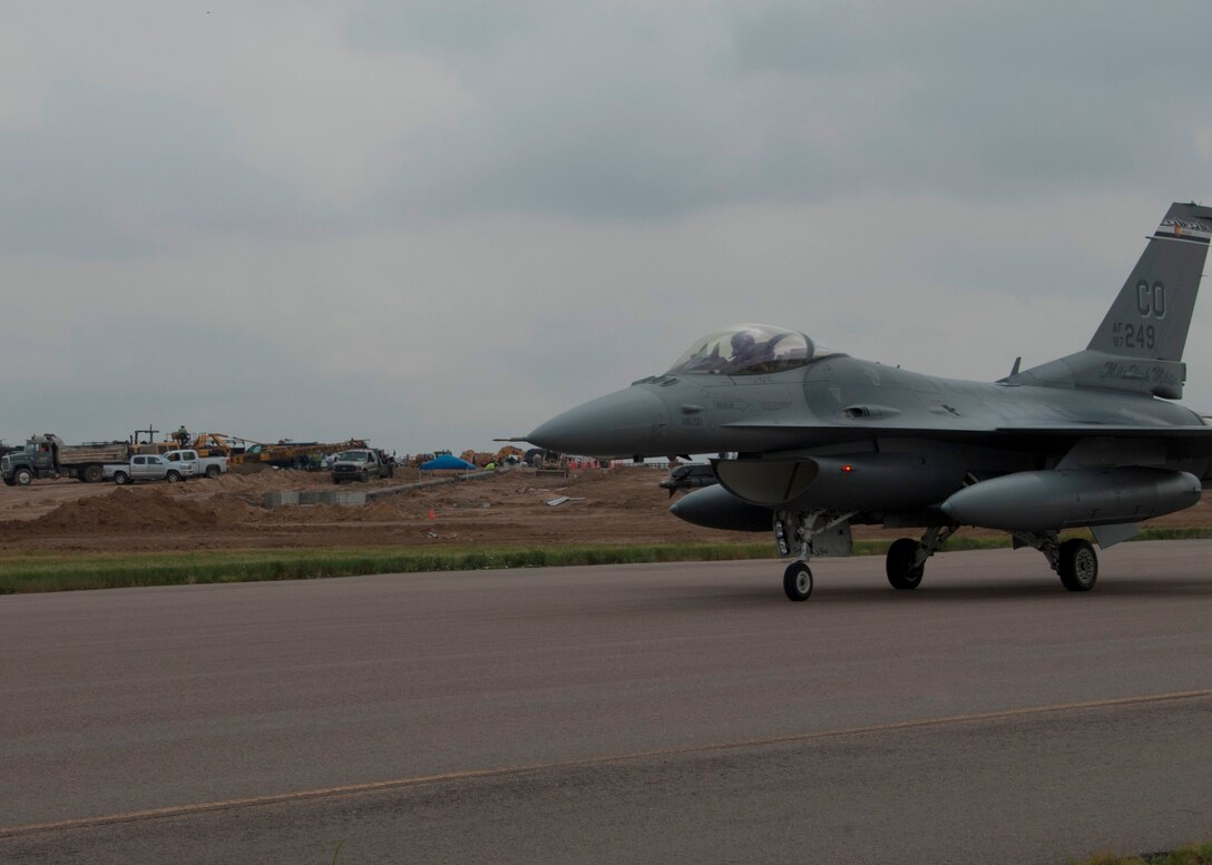 Colorado Air National Guard F-16s return home to Buckley Air Force Base after being housed temporarily at Denver International Airport for the last three months, Buckley AFB, Aurora Colo., July 12, 2014. The partnership between DIA and the COANG  allowed necessary runway reconstruction at Buckley AFB to take place while also providing F-16 pilots the opportunity to continue their 24/7 alert mission and vital training flights twice a day at DIA. Construction on the runway will continue through September, however the airfield is back to operational status. (U.S. Air National Guard photo by Senior Airman Michelle Y. Alvarez-Rea)