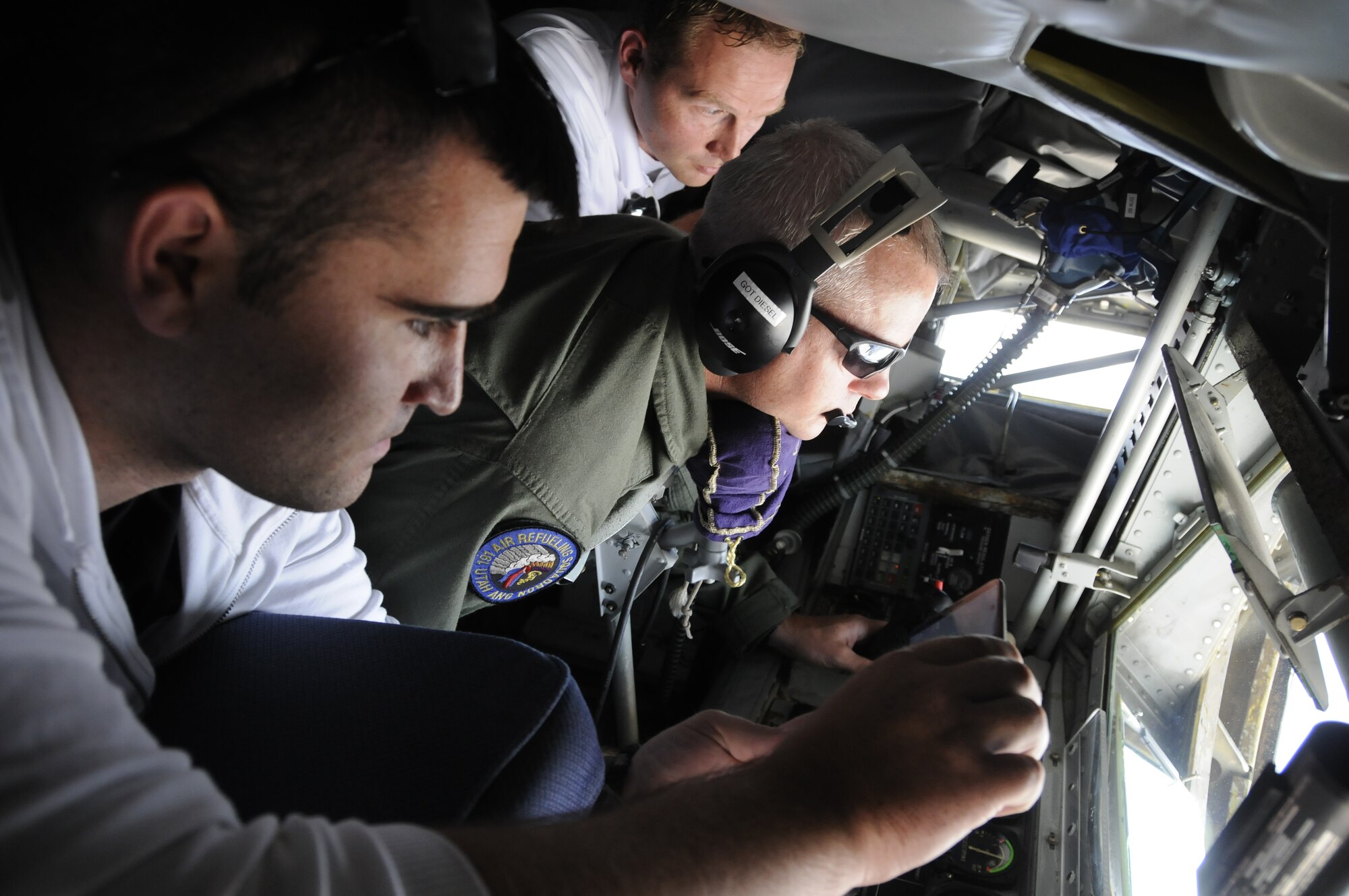 Dario Basnjak, EMC2 and Brent Dewsnup, Goldman Sachs, watch as Master Sgt. Kurt Armstrong, with the Utah Air National Guard, operates the boom during an aerial refueling mission on July 12, 2014, at the Utah Test and Training Range. (U.S. Air Force photo/Senior Airman Allen Stokes)