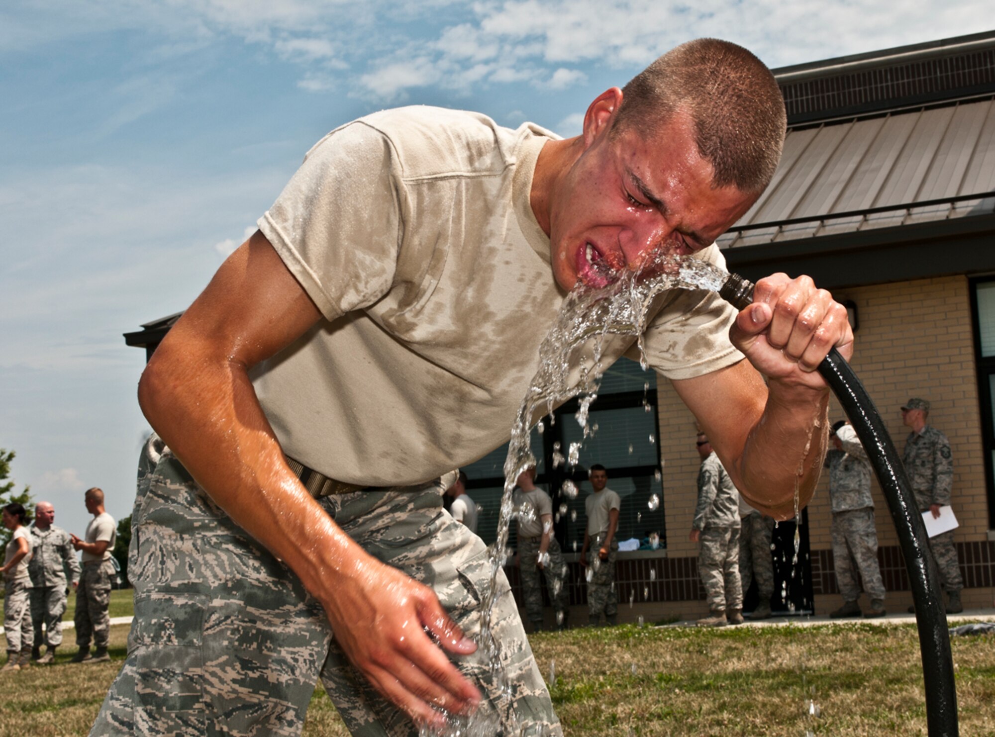 U.S. Air Force Airman 1st Class Joseph Nenadich, 121st Air Refueling Wing Security Forces Squadron, flushes his face with water after being sprayed with Oleoresin Capsicum (OC) spray during OCC training at Rickenbacker Air National Guard Base, Ohio, July 12, 2014. In order for a Security Forces member to be authorized to carry the less than lethal weapon, members must be sprayed with an active agent. (U. S. Air National Guard photo by Tech. Sgt. Zachary Wintgens/Released)