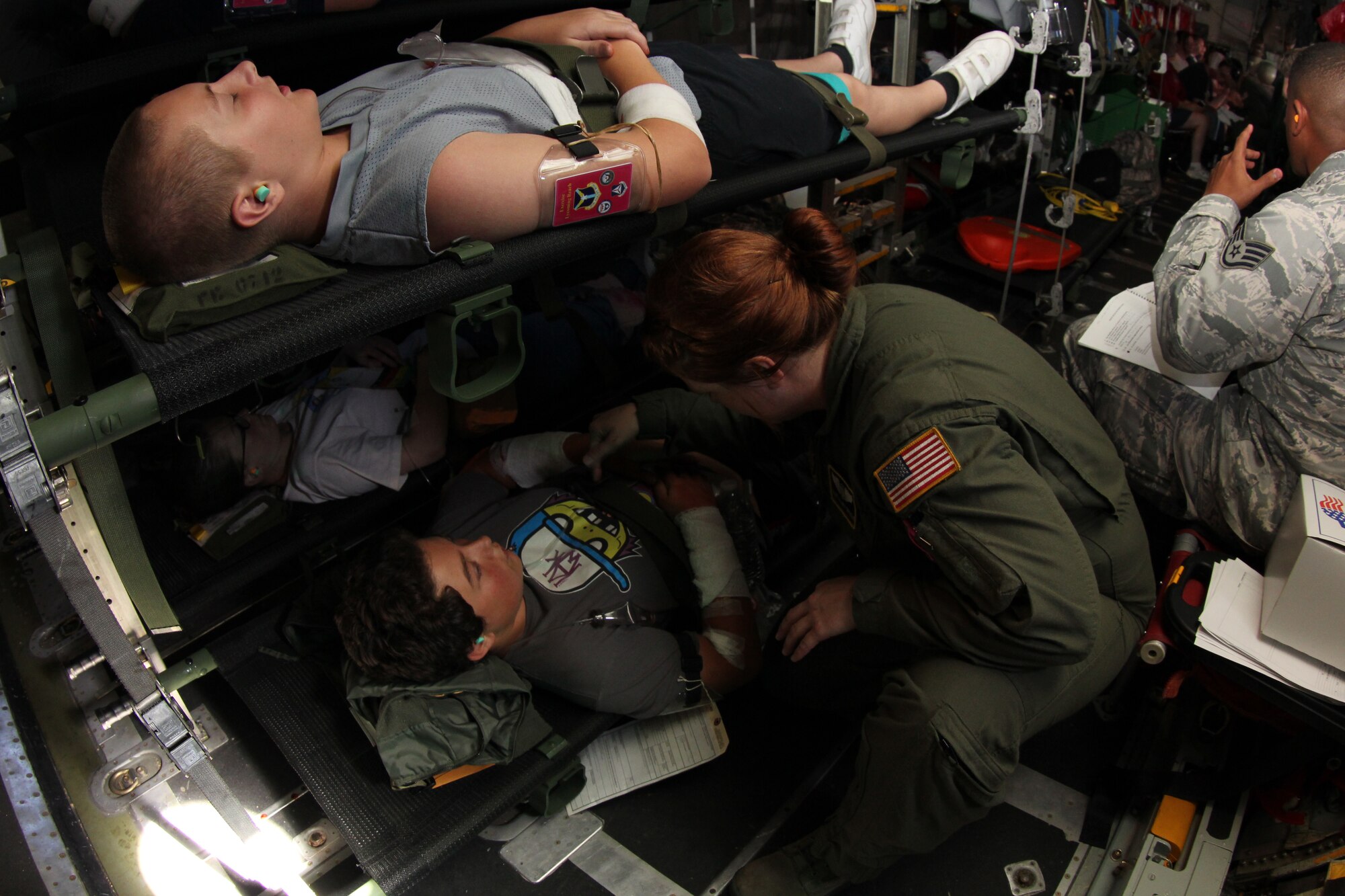 Staff Sgt. Hilary Drogus, 911th Airlift Wing Aeromedical Evacuation Technician, preforms an in-flight patient check on a simulated victim, July 12, 2014. The C-130 flight was part of thea National Disaster Medical System exercise, Lycoming Reach.  (U.S. Air Force photo by Senior Airman Justyne Obeldobel)