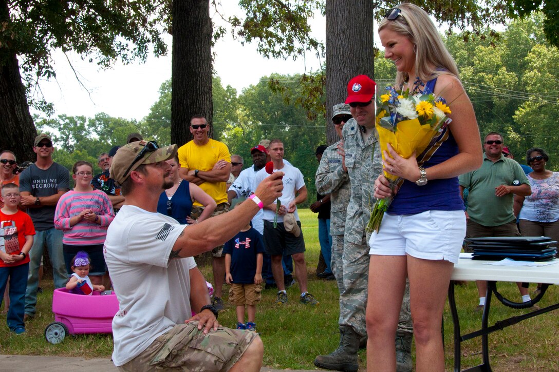 U.S. Air Force Staff Sgt. Kenny McMillen, 307th Rapid Engineer Deployable Heavy Operational Repair Squadron Engineers specialist, surprises his girlfriend, Suzanne Neely, with a marriage proposal during family day activities for the unit at Barksdale Air Force Base, La., July 12, 2014.  Neely thought she was to present a bouquet of flowers to another Airman's spouse when McMillen came out of the crowd, took a knee, and asked for her hand in marriage.  Although surprised, she accepted the proposal as other members of the 307th RED HORSE and their family members cheered for the newly engaged couple.  (U.S. Air Force photo by Tech. Sgt. Ted Daigle/Released)