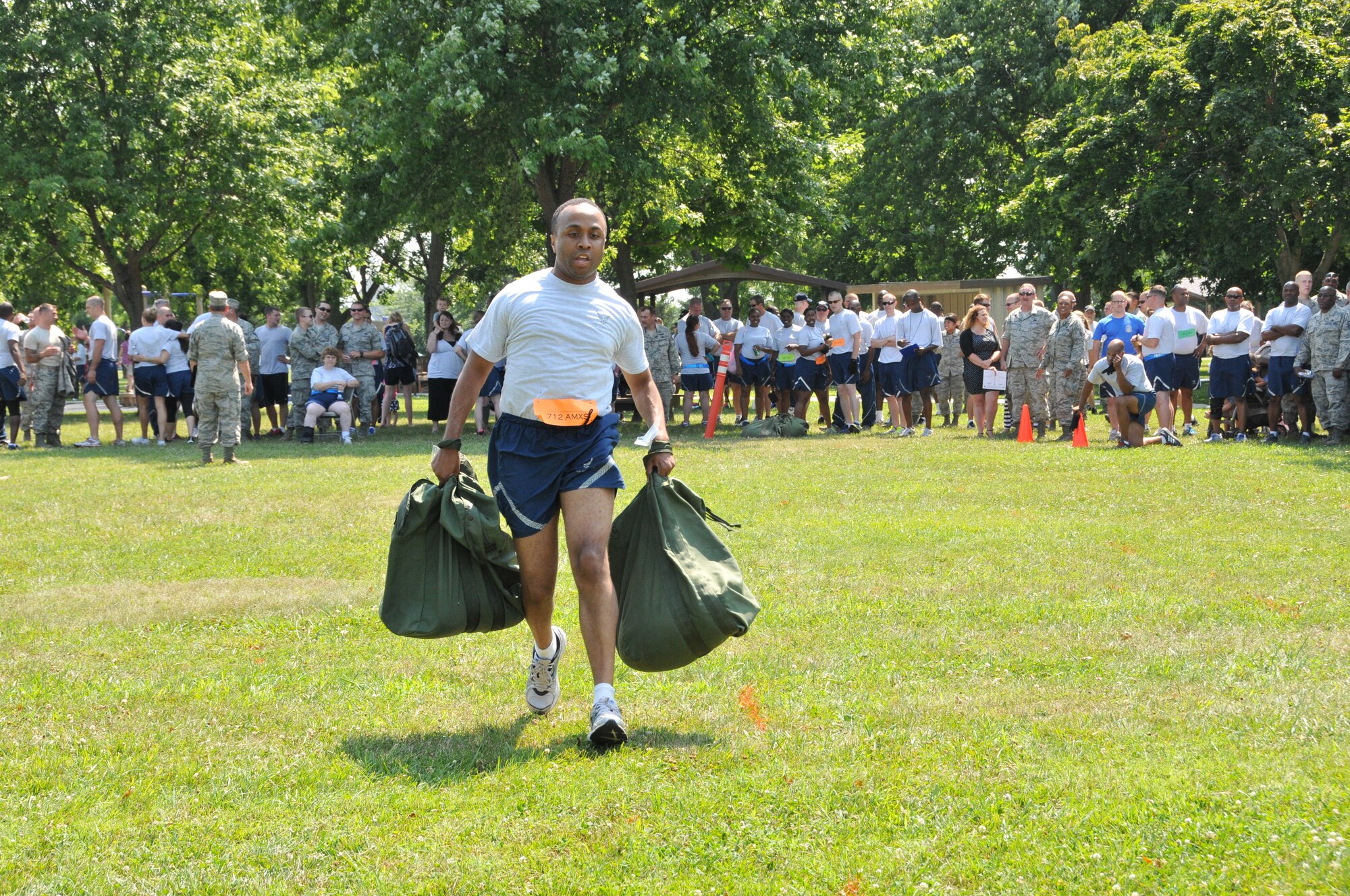 Senior Airman Davon Distance, 712th Aircraft Maintenance Squadron, runs with two weighted bags at the 512th Airlift Wing's Ultimate Fitness Challenge event July 12, 2014 at Dover Air Force Base, Del. The fitness competition, which was sponsored by the wing's Company Grade Office Council, featured other contests like sit-ups, push-ups, a tire flip, and a tug-of-war. (U.S. Air Force photo/Senior Airman Joe Yanik) 