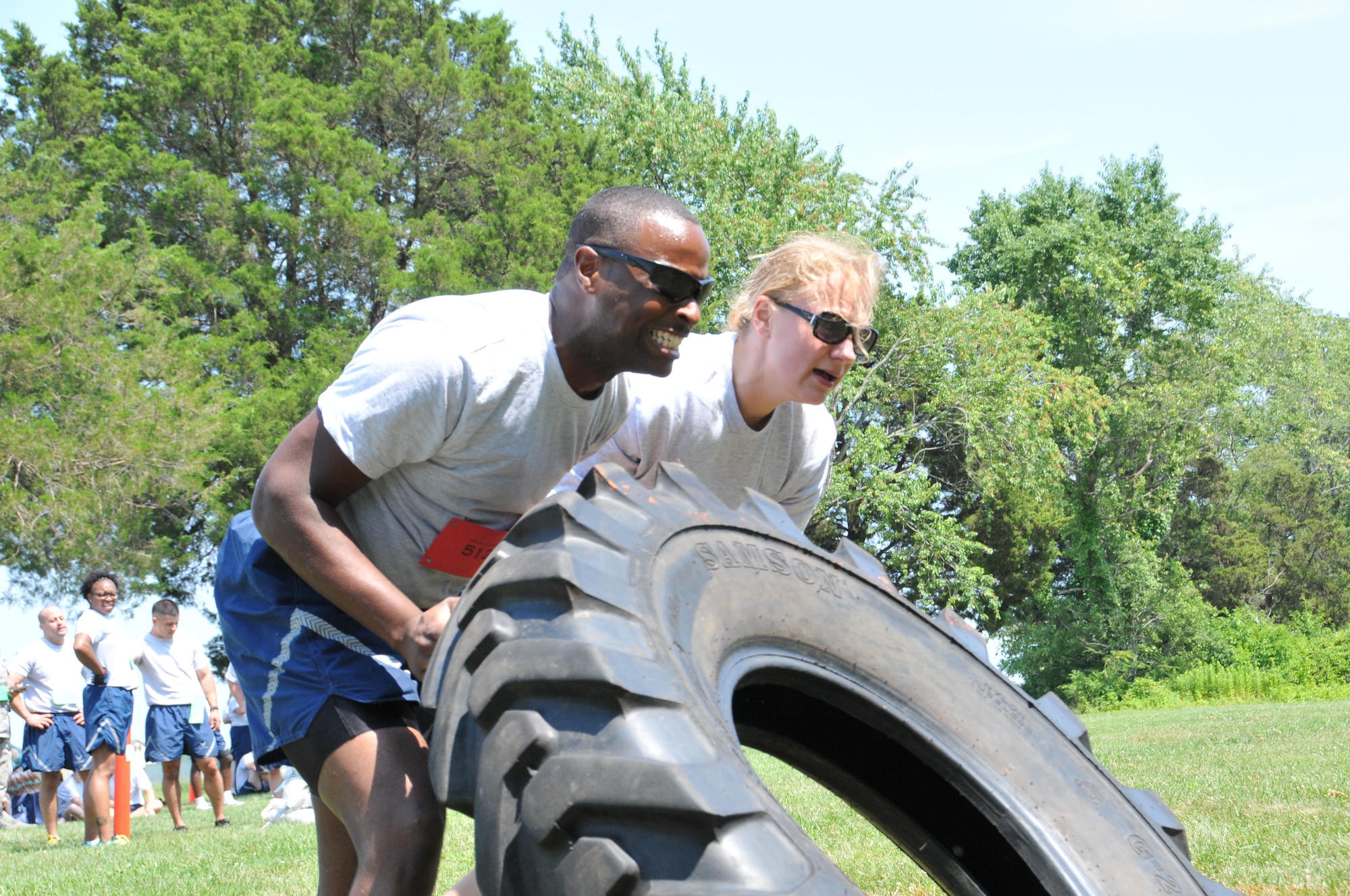 Senior Airman Deion Gilliam (left) and Maj. Mary Lent, 512th Maintenance Squadron, flip a tire during the 512th Airlift Wing's Ultimate Fitness Challenge July 12, 2014 at Dover Air Force Base, Del. The fitness competition, which was sponsored by wing's Company Grade Office Council, featured contests like the tire flip, push-ups, and a tug-of-war. (U.S. Air Force photo/Senior Airman Joe Yanik) 