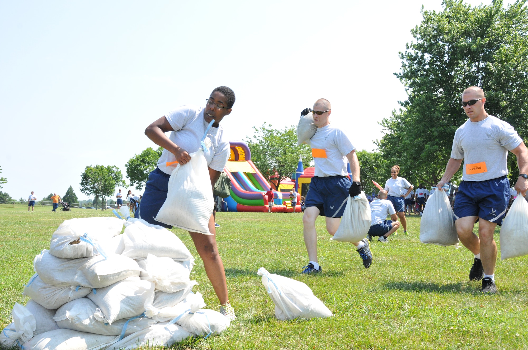 Master Sgt. Nicole Younger (far left), Senior Airman Dylon Everetts (center) and Tech Sgt. Dale Adkins, 712th Aircraft Maintenance Squadron, race to build a wall with weighted bags in the fastest time while competing against other reservists in the wing's Ultimate Fitness Challenge held July 12, 2014 at Dover Air Force Base, Del. The fitness competition, which was sponsored by wing's Company Grade Office Council, featured contests in sit-ups, push-ups, a tire flip, and a tug-of-war. (U.S. Air Force photo/Senior Airman Joe Yanik) 