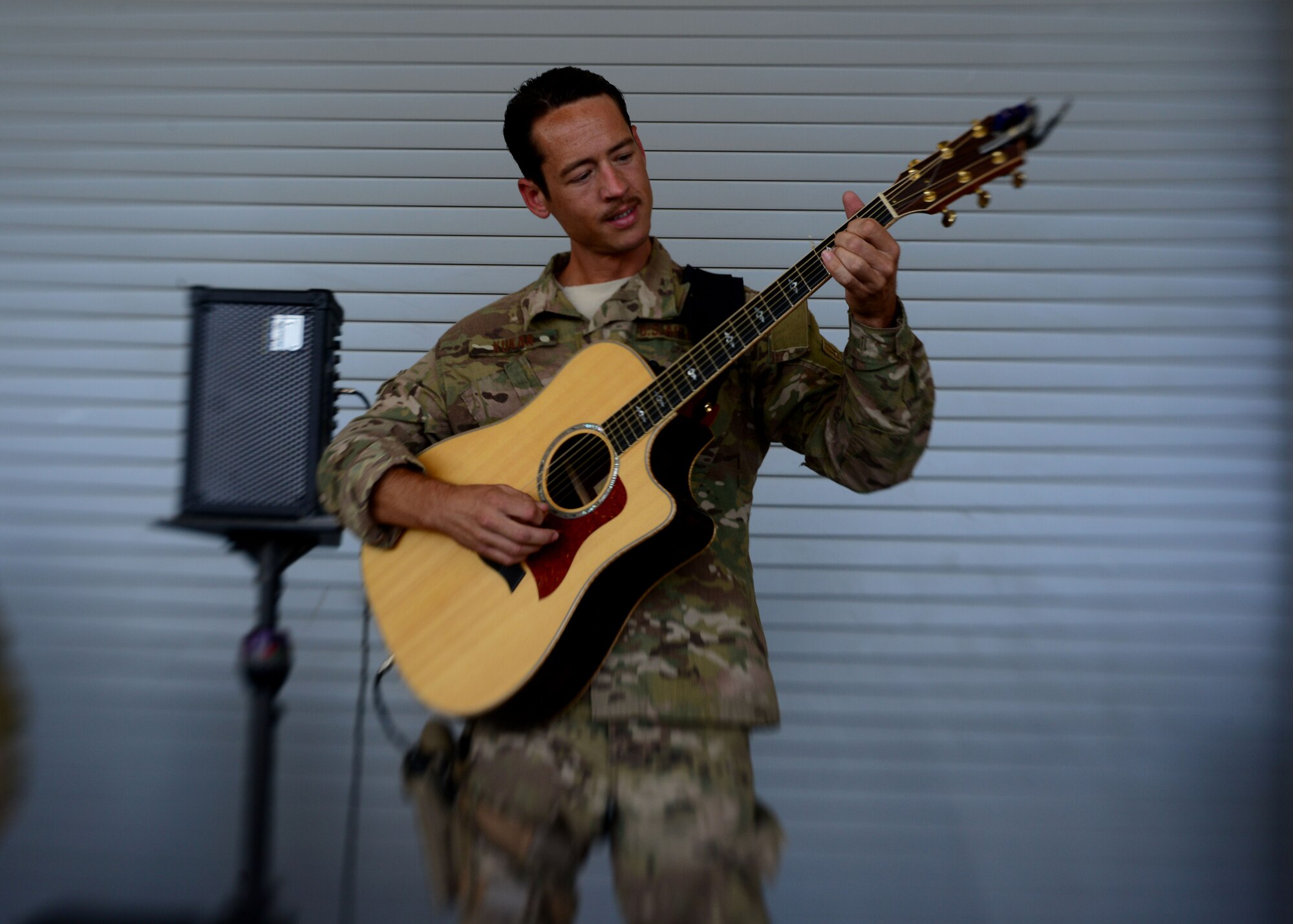 U.S. Air Force Tech. Sgt. Johnny Kukan, Central Command Starflifter Band plays the guitar during a performance for Airmen at Bagram Airfield, Afghanistan July 11, 2014.  The seven-member band spent three days here entertaining service members. Kukan is deployed from Scott Air Force Base, Ill. and a native of Uniontown, Pa. (U.S. Air Force photo by Staff Sgt. Evelyn Chavez/Released)