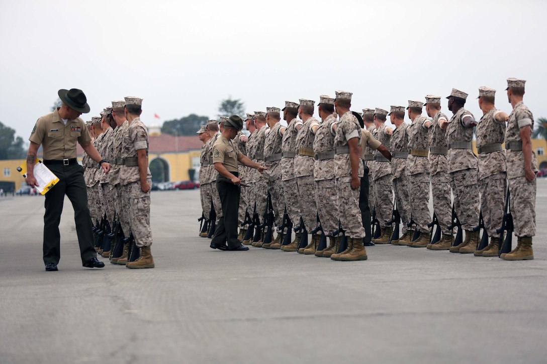 Drill masters grade recruits of Echo Company, 2nd Recruit Training Battalion, on their uniforms and positioning during Final Drill aboard Marine Corps Recruit Depot San Diego, Calif., June 30. Every platoon is graded in the event.