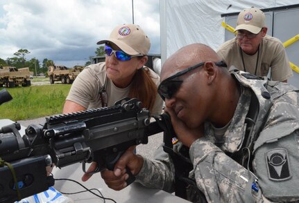 Contractors from XCTC watch as Pfc. Calin Stewart of C Company, 2nd Battalion, 124th Infantry Regiment, sites his M-249 light machine gun using electronic sensors and equipment at Camp Blanding Joint Training Center, Fla., July 12, 2014. More than 4,500 Infantry Soldiers from the Florida Army National Guard were at Camp Blanding in late July for the XCTC training. 