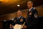 Master Sgt. Roger Sparks, and Maj. Joseph Conroy, both with the 212th Rescue Squadron, Alaska Air National Guard, hold an award citation during a ceremony on Joint Base Elmendorf-Richardson, July 11. Sparks was awarded the Silver Star, the nation’s third-highest award for valor, for his role in a firefight with insurgents during Operation Bulldog Bite in Afghanistan’s Watapur Valley on Nov. 14, 2010. His actions during the combat operation resulted in four American lives being saved and four casualties being returned to their families with honor and dignity. 
