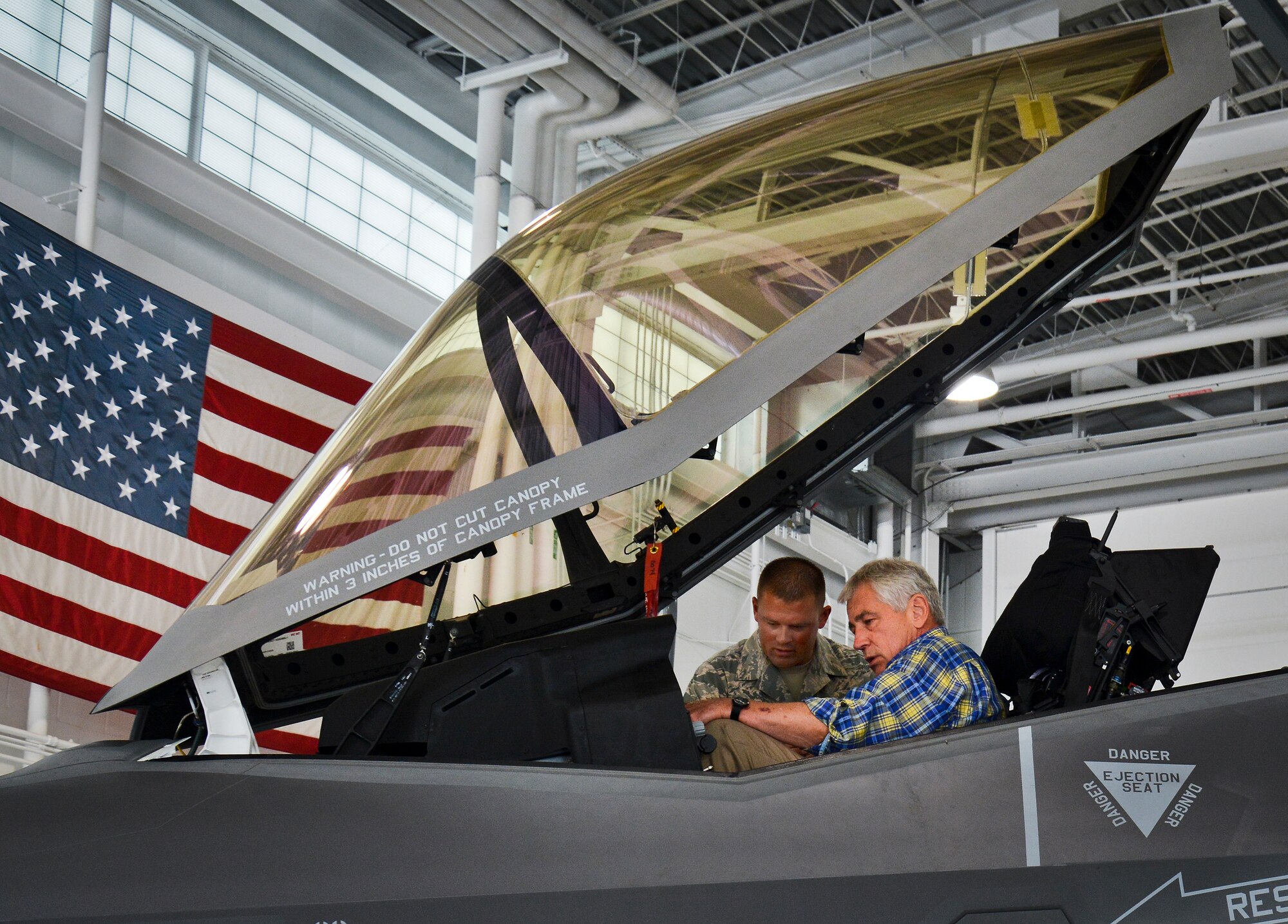 Tech. Sgt. Michael McClure briefs Defense Secretary Chuck Hagel on the cockpit of the F-35A Lightning II July 10, 1014, at Eglin Air Force Base, Fla. Hagel visited the base to tour the 33rd Fighter Wing and F-35 Lightning II integrated training center. McClure is a member of the 33rd Aircraft Maintenance Squadron. (U.S. Air Force photo/Linda Phillips)
