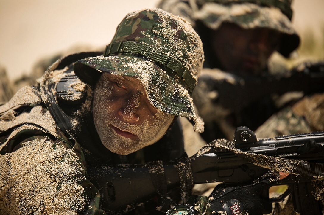 A soldier with the Japan Ground Self-Defense Force waits for his squad leader to give the signal to advance positions during an amphibious assault at Pyramid Rock Beach, July 1, 2014. The JGSDF conducted the training exercise with U.S. Marines with 3rd Reconnaissance Battalion, based in Okinawa, Japan. The world's largest international maritime exercise, Exercise Rim of the Pacific 2014, provides a unique training opportunity that helps participants foster and sustain the cooperative relationships that are critical to ensuring the safety of sea lanes and security on the world's oceans. Twenty-two nations, more than 40 ships, six submarines, more than 200 aircraft and 25,000 personnel are participating in RIMPAC. (U.S. Marine Corps photo by Cpl. Matthew J. Bragg)