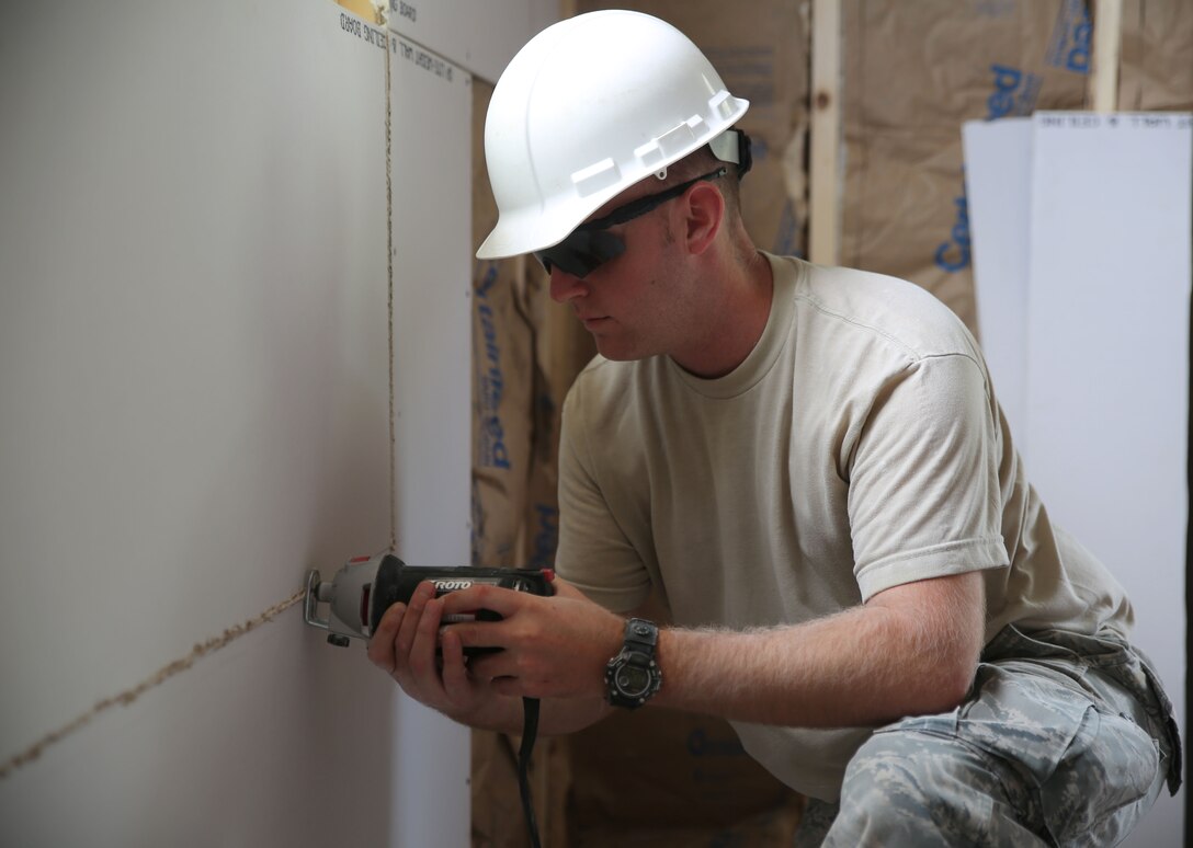 CAMP WILLIAM HINDS, RAYMOND, Maine – Air Force Staff Sgt. Eric Krackenberger, an electrical systems specialist with the 161st Air Refueling Wing, Arizona Air National Guard and native of Phoenix, Arizona, trims excess drywall from a window frame in the new addition of the Rotary Scout Training Center during the joint service Innovative Readiness Training on Camp William Hinds in Raymond, Maine, July 10, 2014. IRT Camp Hinds is a joint service initiative designed to provide service memebers with real-world training opportunities preparing them for their war-time missions while also supporting the needs of America’s underserved communities. (Photo by Sgt. Adwin Esters/Released 140710-M-JL916-098)
