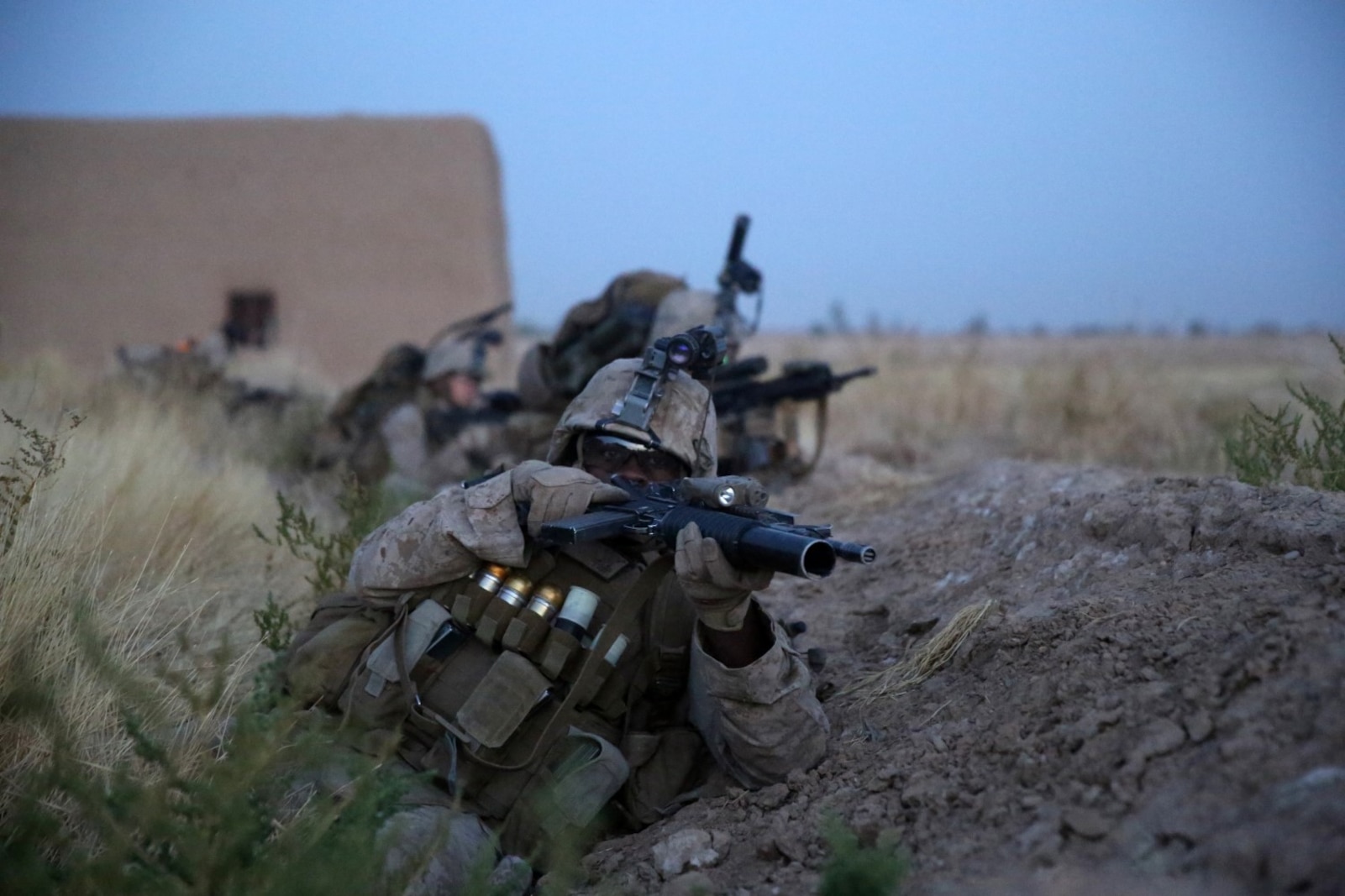 Corporal Deshaun Jackson, rifleman, Bravo Company, 1st Battalion, 7th Marine Regiment, takes cover behind a berm during a firefight in Helmand province, Afghanistan, July 6, 2014. Jackson, a native of Chicago, and the company operated in Gereshk for three days and were involved in numerous kinetic engagements with Taliban insurgents. (U.S. Marine Corps photo by Cpl. Joseph Scanlan / released)