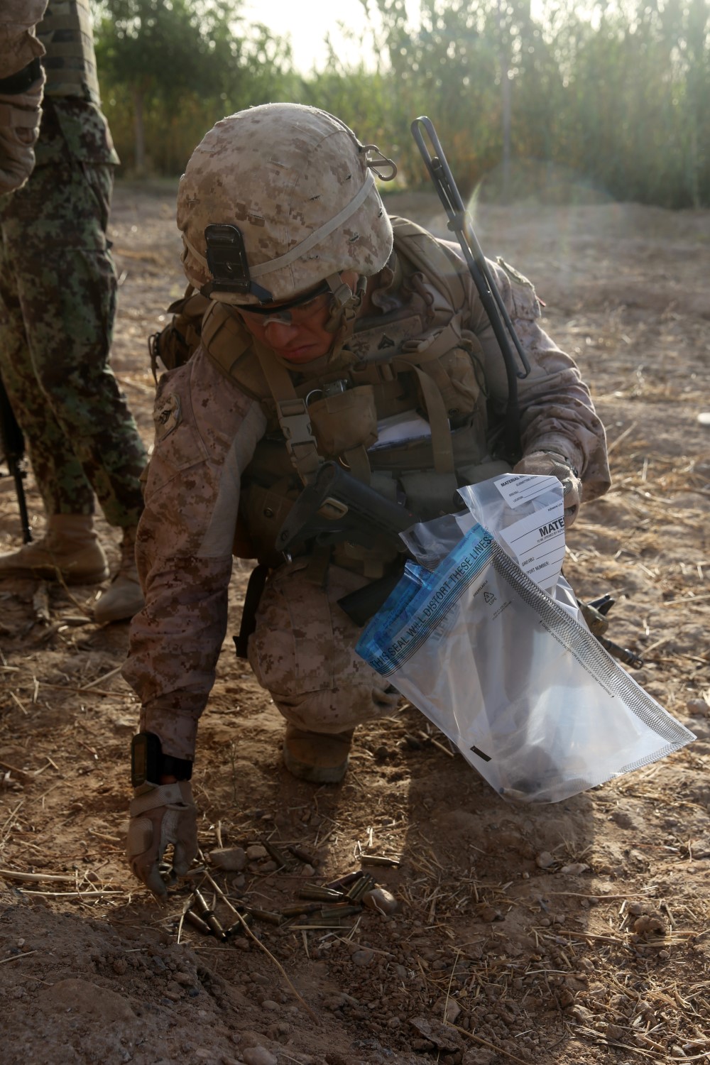 Corporal Eric Garcia, squad leader, Bravo Company, 1st Battalion, 7th Marine Regiment, gathers expended munitions from an insurgent's shooting position after a firefight in Helmand province, Afghanistan, July 6, 2014. Garcia, a native of Waukegan, Ill., and the company operated in Gereshk for three days and were involved in numerous kinetic engagements with Taliban insurgents.
(U.S. Marine Corps photo by Cpl. Joseph Scanlan / released)