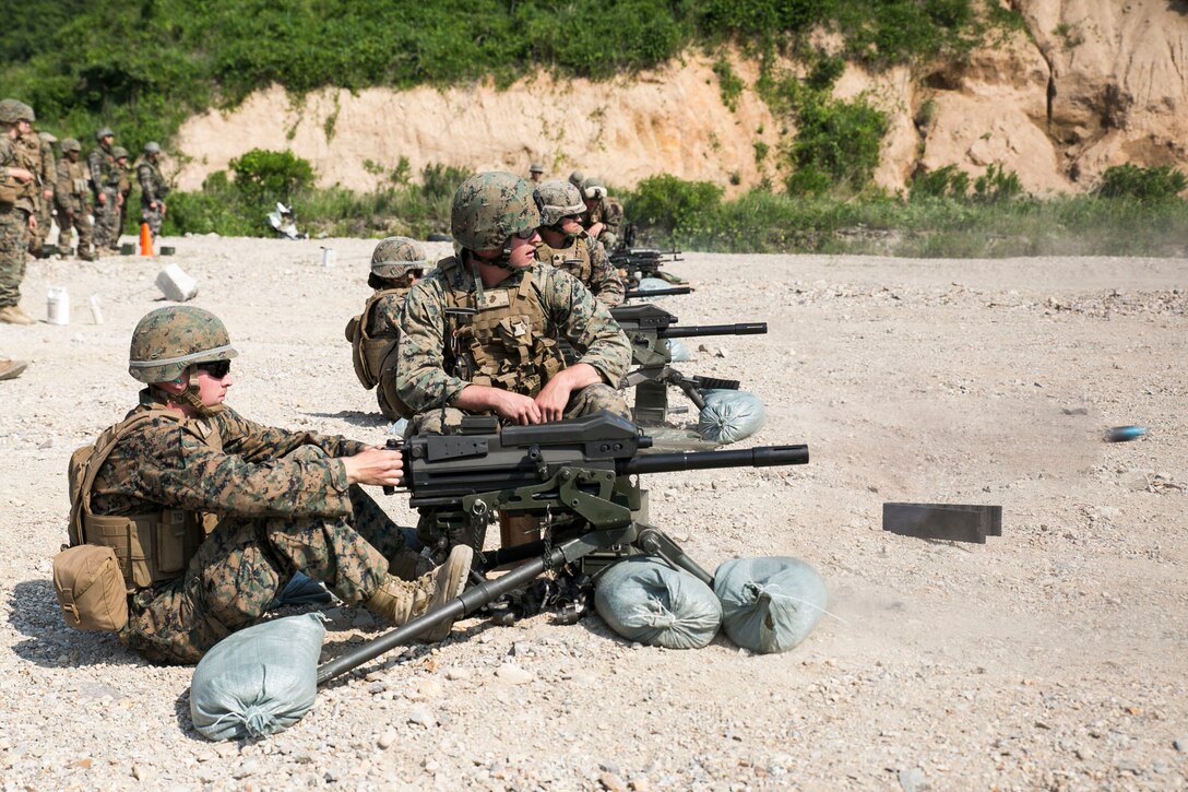 U.S. Marine Pfc. Joshua C. Haynie, left, fires the MK19 40 mm automatic grenade launcher as U.S. Marine Cpl. John L. Salter, center, looks on during live-fire training June 18 as part of Korean Marine Exchange Program 14-8 at the Susungri Range in Pohang, South Korea. KMEP 14-8 is one iteration in a series of combined training exercises that promotes stability on the Korean Peninsula and strengthens ROK and U.S. military capabilities and interoperability. Haynie is a Colorado Springs, Colorado, native and military policeman with 3rd Law Enforcement Battalion, III Marine Expeditionary Force Headquarters Group, III MEF. Salter is a Mars, Pennsylvania, native and special reaction team member with 4th Law Enforcement Battalion, Force Headquarters Group, Marine Forces Reserve.  (U.S. Marine Corps photo by Lance Cpl. Drew Tech/Released)