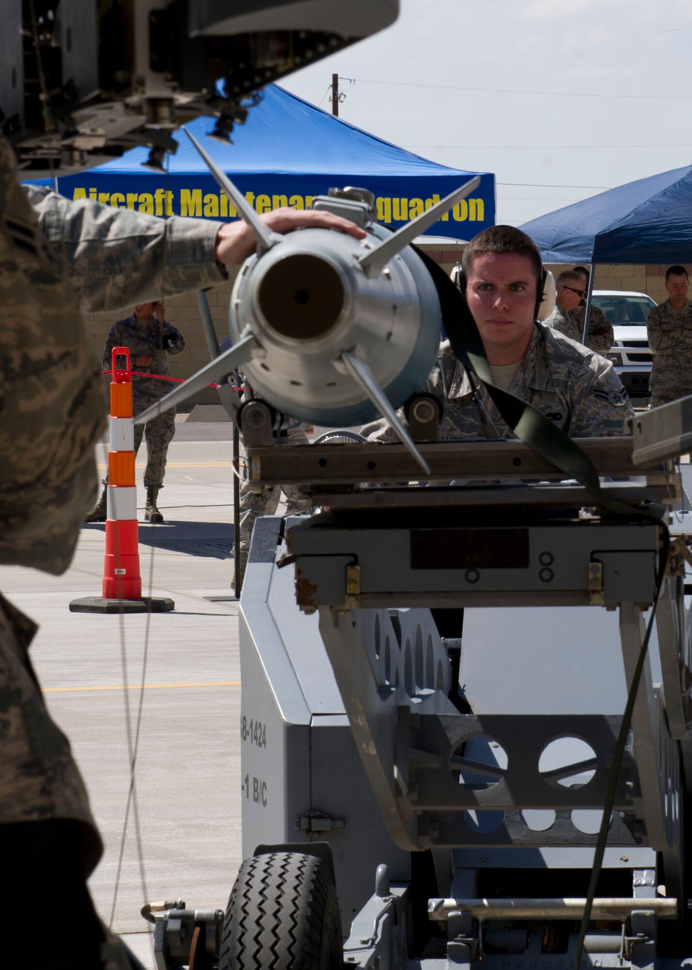 Airman 1st Class Christopher Williamson, 49th Maintenance Group MQ-9 Reaper weapons load crew 58 member, guides a GBU-12 Paveway bomb to the MQ-9 during the third quarterly load crew competition at Holloman Air Force Base, N.M., July 11. The MQ-9 load crew participated in the competition to have their skills evaluated alongside the F-16 Fighting Falcon load crews. For the competition, points are awarded for weapons-loading, toolkit inspection, and uniform inspection. (U.S. Air Force Staff Sgt. E’Lysia A. Wray/Released)