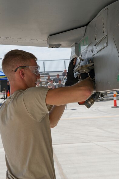 Senior Airman Joshua Parker, 54th Fighter Group F-16 Fighting Falcon weapons load crew 102 member, prepares an F-16 for weapons-loading during the third quarterly load crew competition at Holloman Air Force Base, N.M., July 11. The F-16 load crew participated in the competition to have their skills evaluated alongside the MQ-9 Reaper load crews. For the competition, points are awarded for weapons-loading, toolkit inspection, and uniform inspection. (U.S. Air Force Staff Sgt. E’Lysia A. Wray/Released)
