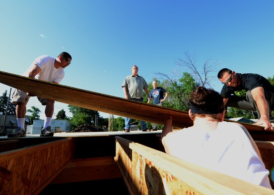 Airmen from the 341st Missile Wing lay down plywood for a Habitat for Humanity home in Great Falls, Mont., July 12. A dozen Malmstrom Airmen volunteered about six hours laying subfloor for the Habitat for Humanity house. Habitat is an international nonprofit organization that builds and repairs homes for qualified low-income families, solely through volunteer labor and donations. (U.S Air Force photo/Senior Airman Katrina Heikkinen) 