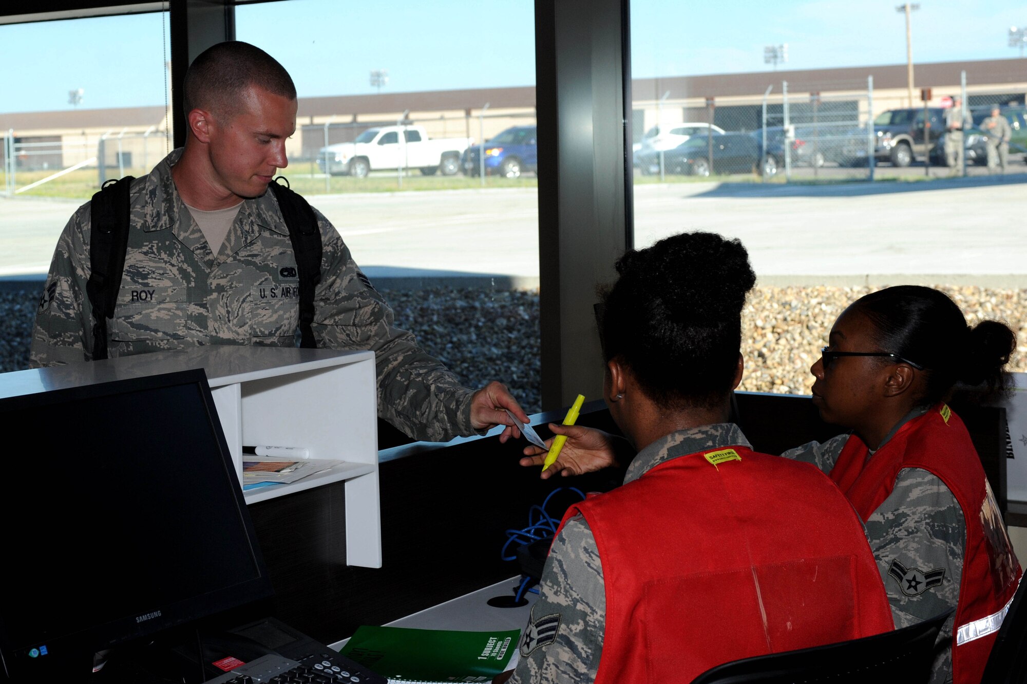Senior Airman Jordan Roy, 28th Aircraft Maintenance Squadron B-1 bomber assistant dedicated crew chief, provides his military ID to Deployment Center staff to start his mobility processing line activities at Ellsworth Air Force Base, S.D., July 11, 2014. Roy is one of approximately 170 Ellsworth Airmen participating in a Red Flag exercise at Nellis Air Force Base, Nev. (U.S. Air Force photo by Senior Airman Hailey R. Staker/Released)