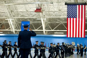 Col. Bill Knight salutes U.S. Air Force Band and Honor Guard members as they perform a pass in review at his change of command ceremony at Joint Base Andrews, Md., July 14, 2014. The ceremony transfers 11th Wing/JBA command from Knight to Col. Bradley Hoagland. (U.S. Air Force photo/Senior Airman Mariah Haddenham)