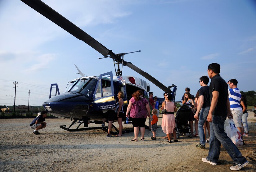 Spectators are given a tour of a UH-1N Huey helicopter from the 1st Helicopter Squadron at the Joint Base Andrews Heritage Park Concert, July 12, 2014. The concert series was designed to show appreciation to the local community for their support and showcase JBA's dedicated Airmen. This was the second of three concerts scheduled for this summer. (U.S. Air Force photo/Tech. Sgt. Brian Ferguson)