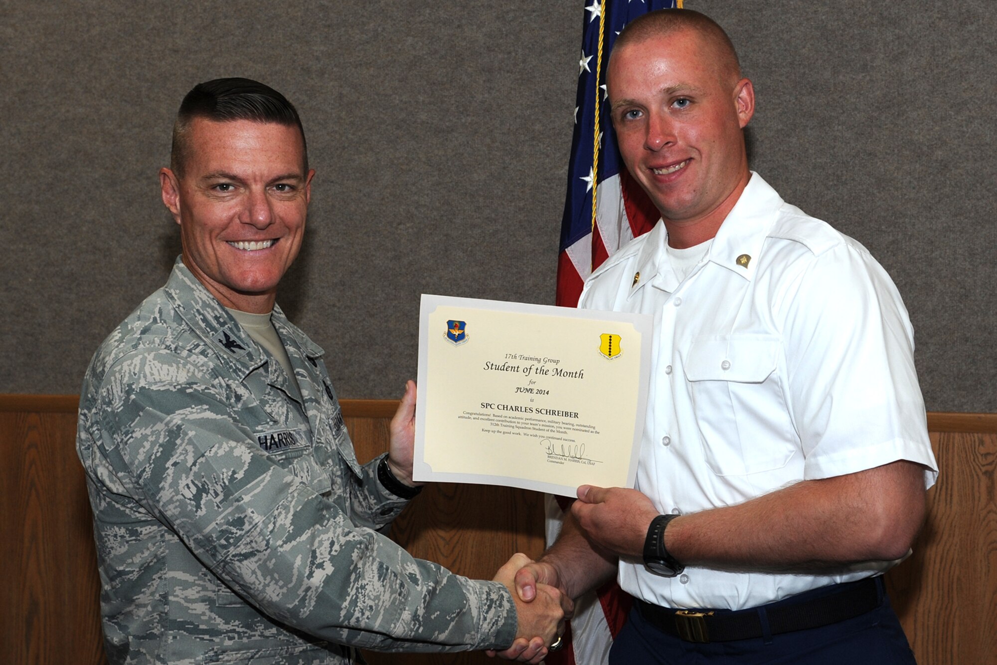GOODFELLOW AIR FORCE BASE, Texas -- Col. Brendan M. Harris, 17th Training Group Commander, presents the 312th Training Squadron Enlisted Student of the Month award for June 2014 to Army Spc. Charles Schreiber July 11. (U.S. Air Force photo/ Senior Airman Michael Smith)