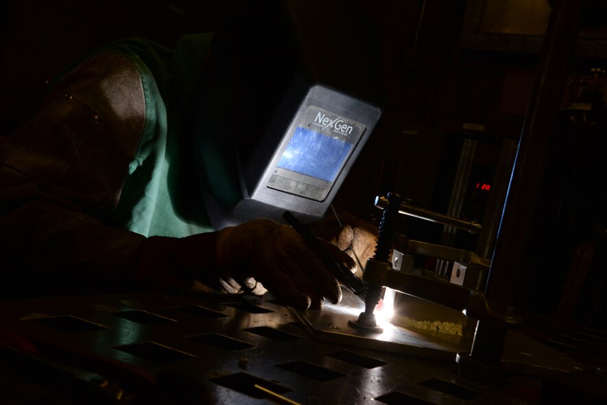 Senior Airman Deryc Coulson, 23rd Equipment Maintenance Squadron fabrications flight metals technology journeyman, cautiously melts aluminum to the maintenance stand of a .50-caliber machine gun July 11, 2014, at Moody Air Force Base, Ga.  The fabrications flight supports all aircraft as well as other units on base. (U.S. Air Force photo by Staff Sgt. Eric Summers Jr./Released)