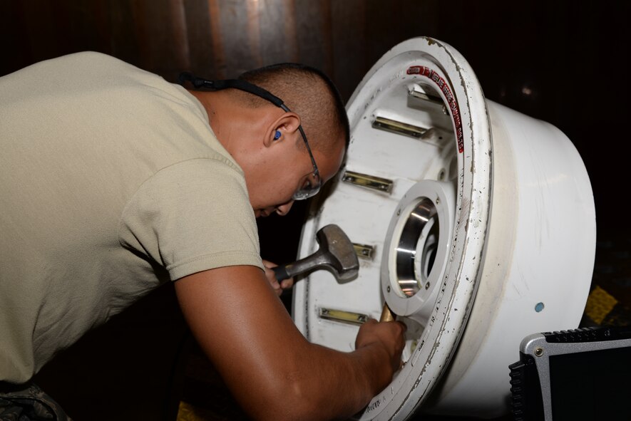Airman 1st Class Tommy Kun, 23d Equipment Maintenance Squadron fabrications flight aircraft metals technology apprentice, loosens studs on a C-130 main landing gear July 11, 2014, at Moody Air Force Base, Ga. The fabrications flight is responsible for fixing and producing replacement aircraft parts.  (U.S. Air Force photo by Staff Sgt. Eric Summers Jr./Released)