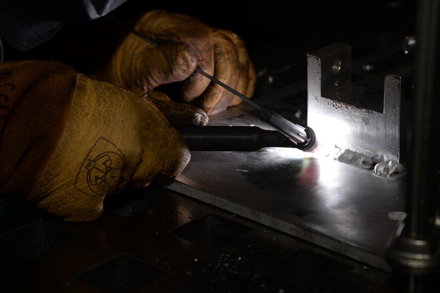 Senior Airman Deryc Coulson, 23d Equipment Maintenance Squadron fabrications flight aircraft metals technology journeyman, heats aluminum to more than 1,200 degrees Fahrenheit to weld the maintenance stand of a .50-caliber machine gun July, 11, 2014, at Moody Air Force Base, Ga. The 23d Equipment Maintenance Squadron fabrications flight frequently interacts with the heated materials to make repairs to aircraft and maintenance parts. (U.S. Air Force photo by Staff Sgt. Eric Summers Jr./Released)