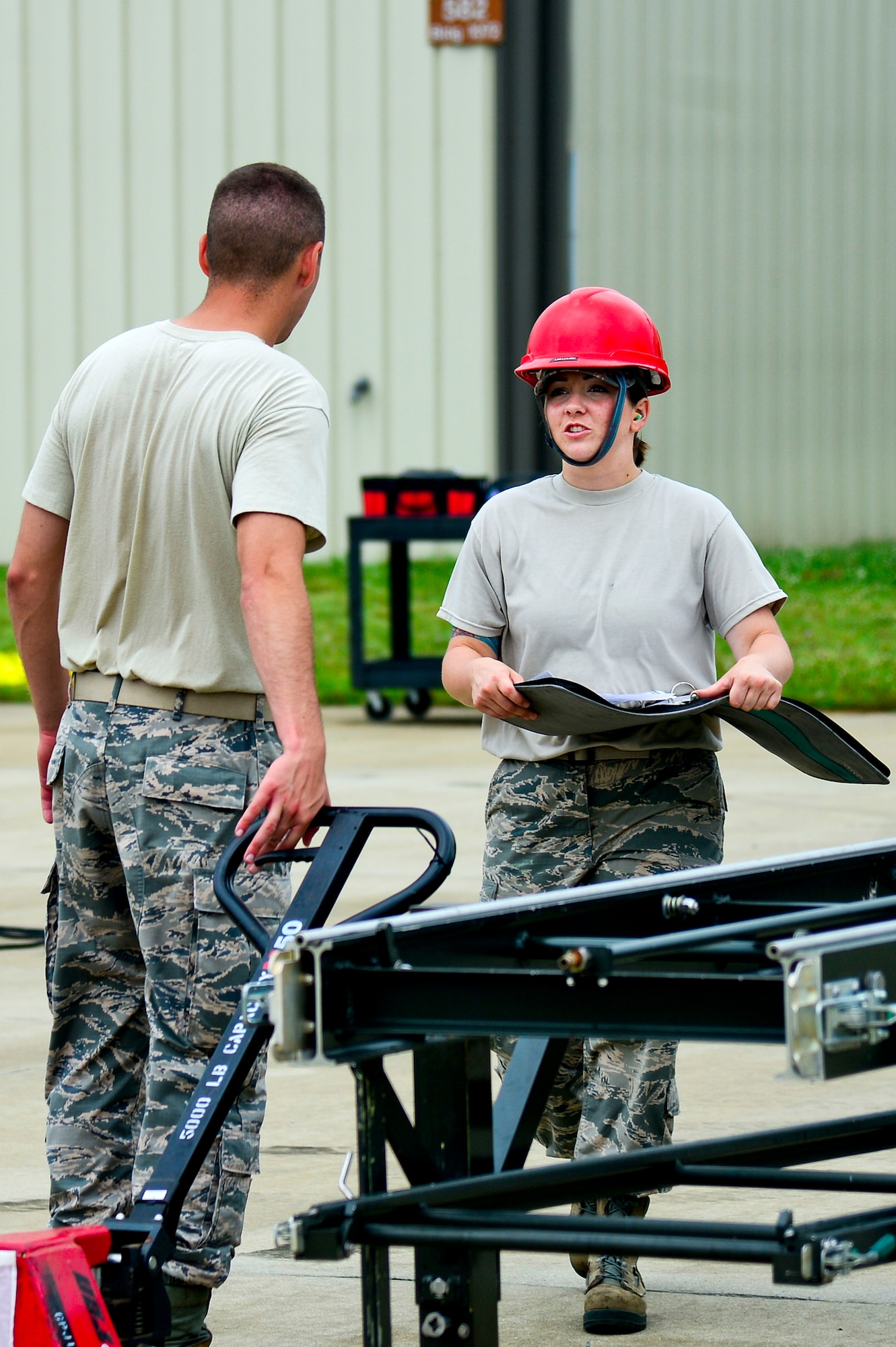 U.S. Air Force Staff Sgt. Victoria Yale, 2014 Air Combat Command Munitions Supervisor of the Year, instructs an Airman during a munitions assembly conveyer build at Langley Air Force Base, Va., June 12, 2014. Yale said success comes from committing time and effort to Airmen in order to build a strong foundation for them. (U.S. Air Force photo by Senior Airman Kayla Newman/Released) (photo cropped and color corrected for effect)