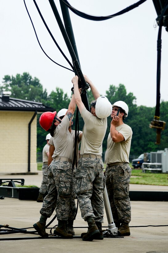 Members of the 1st Maintenance Squadron perform a munitions assembly conveyer build directed by U.S. Air Force Staff Sgt. Victoria Yale, 2014 Air Combat Command Munitions Supervisor of the Year, at Langley Air Force Base, Va., June 12, 2014. Yale believes asking for help is a sign of strength, and encourages Airmen to always seek support. (U.S. Air Force photo by Senior Airman Kayla Newman/Released) (photo cropped and color corrected for effect)