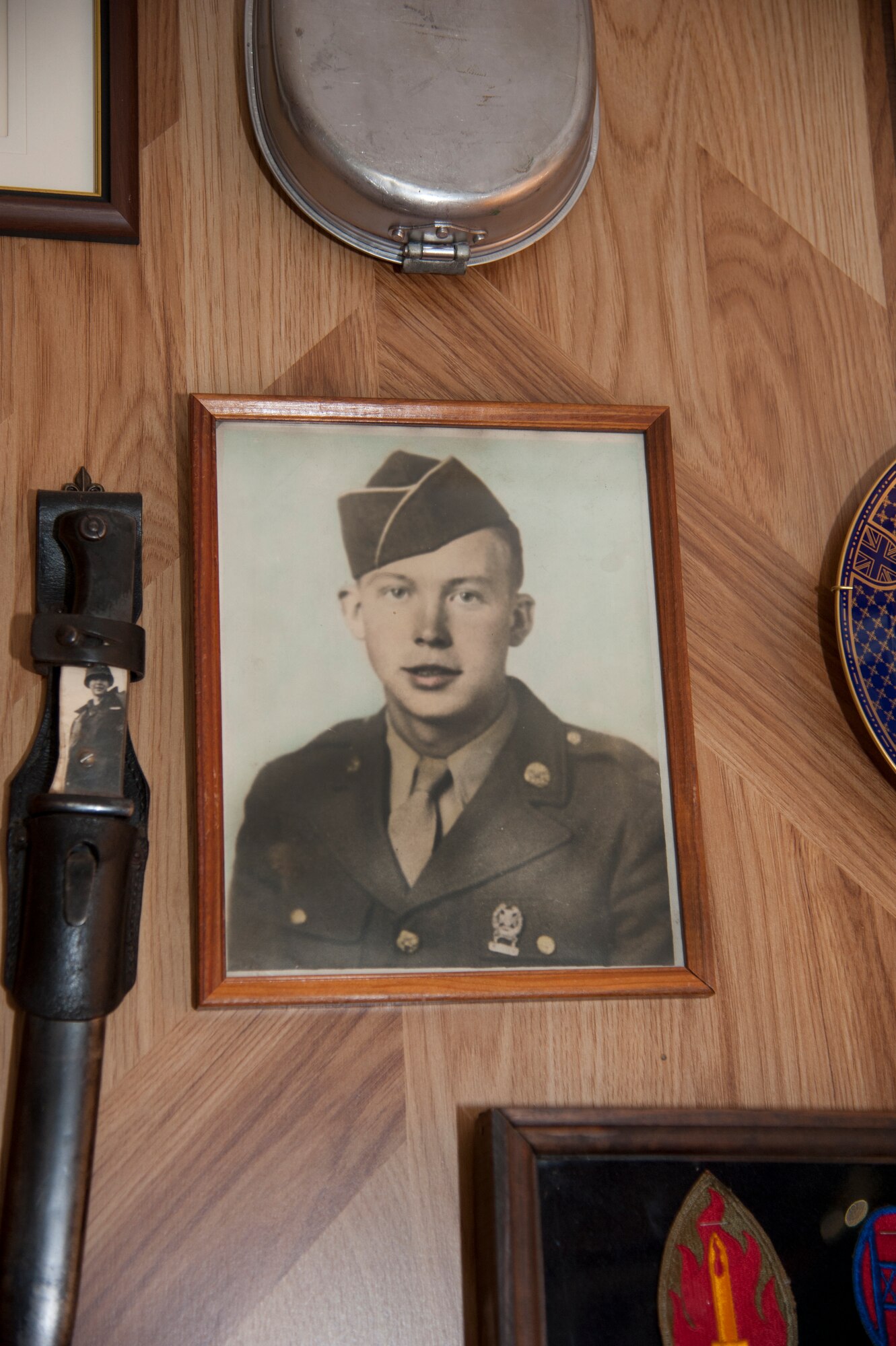 D-Day veteran and Hampton, Va., resident Lee Boone displays his initial enlistment photograph and other service memorabilia in his home. Boone recently received the French Legion of Merit for his service in France on D-Day. (U.S. Air Force photo by Melissa Walther/Released)