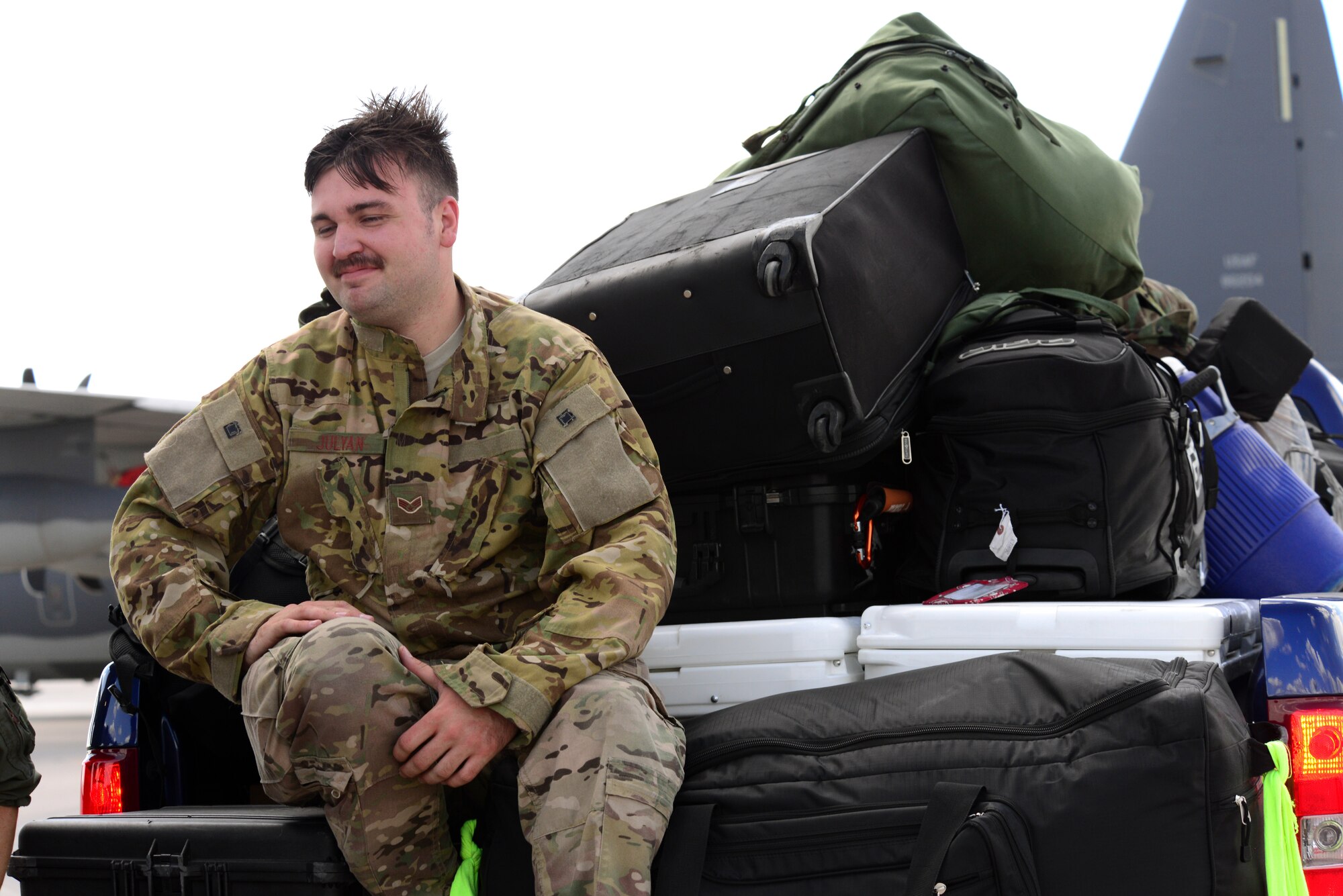 U.S. Air Force Senior Airman Tyler Julyan, 522nd Special Operations Squadron loadmaster, takes a break in the bed of a truck overflowing with supplies from an around-the-world mission July 9, 2014 at Cannon Air Force Base, N.M. Julyan was one of two loadmasters on a mission that sent him around the world in an MC-130J Commando II, the first circumnavigation of the globe in a continuous mission for the aircraft.  