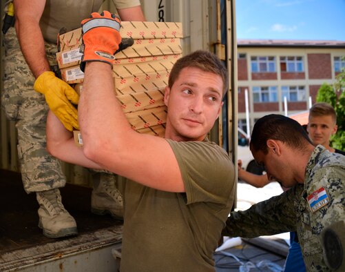 U.S. Air Force Airmen from the 133rd and 148th Civil Engineering Squadron and 219th Red Horse Squadron in partnership with the Croatian Army unload school supplies at an elementary school in Ogulin, Croatia, July 3, 2014. The school supplies were donated from school closures in Germany, base closures at U.S. Army installations in Europe and other various locations. (U.S. Air National Guard photo by Staff Sgt. Austen Adriaens/Released)