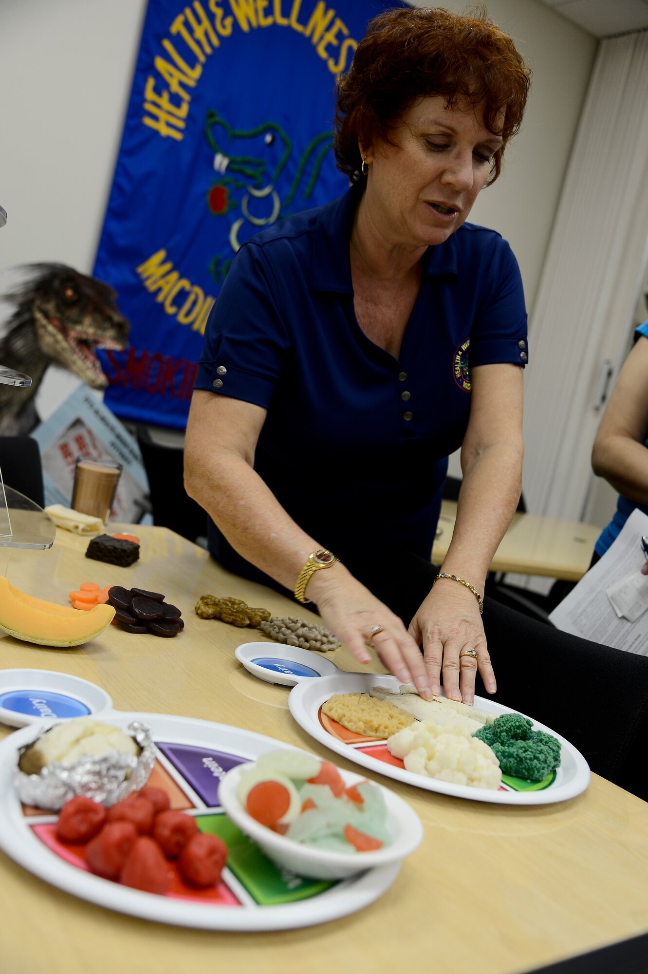 Susan Haley, 6th Areospace Medicine Squadron health promotion dietitian, explains food portions during a Better Body, Better Life class July 10, 2014 at MacDill Air Force Base, Fla. Haley uses the food plate to illustrate healthy food portion sizes during the various meals of the day. (U.S. Air Force photo by Senior Airman Jenay Randolph/Released)